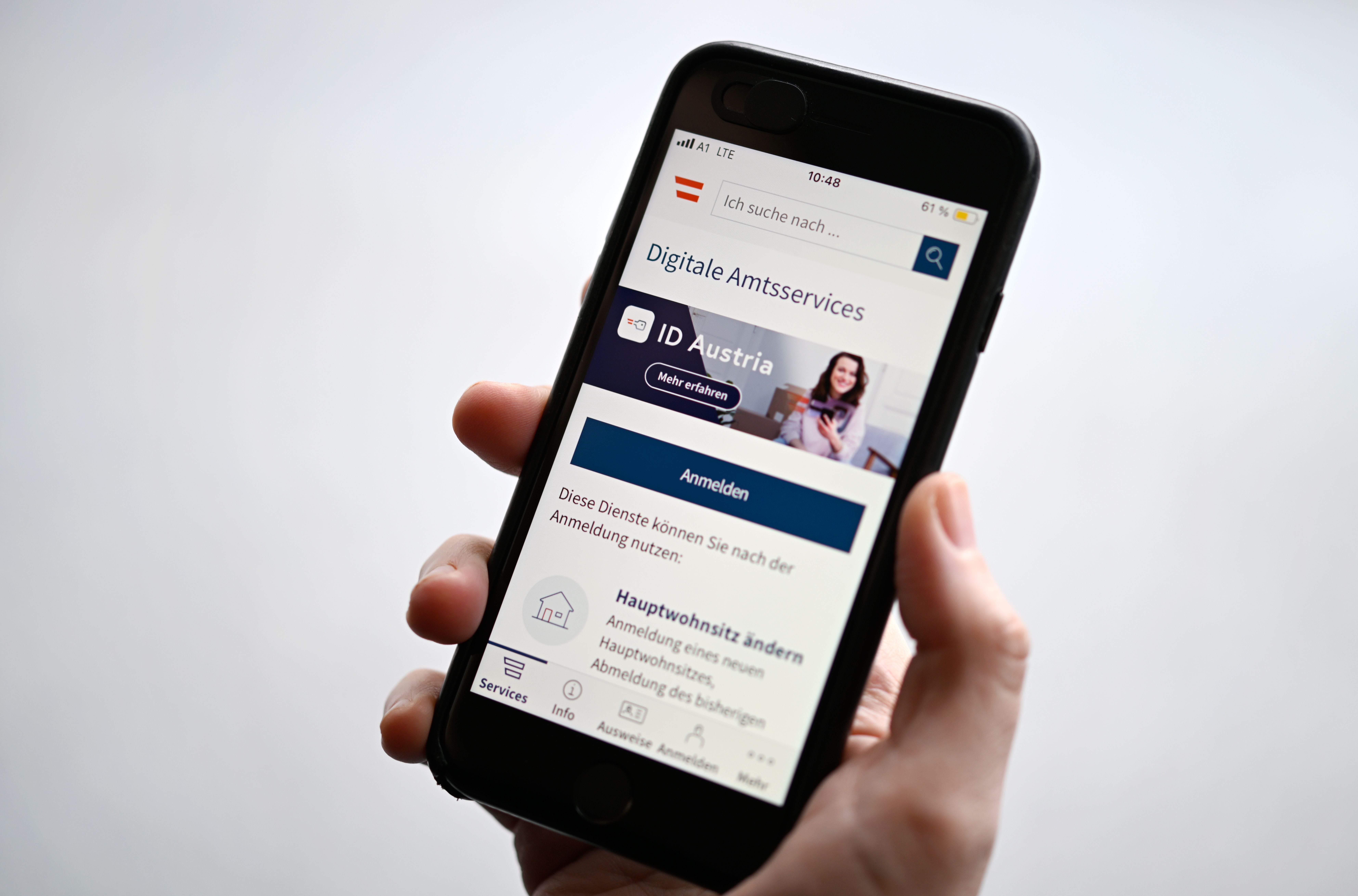 Eine Hand hält ein Smartphone mit geöffneter ID-Austria-App für digitale Amtsservices.