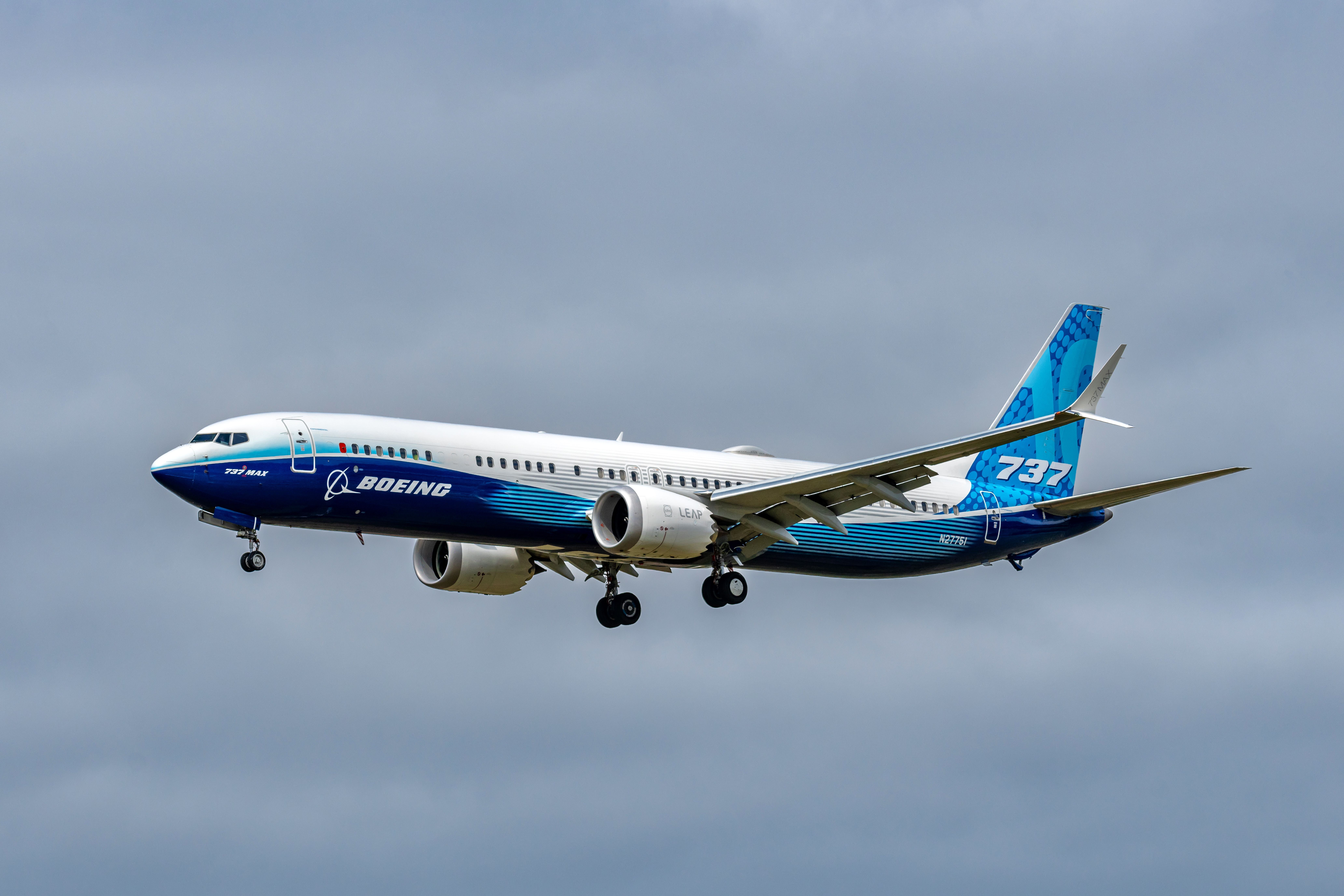 Ein Boeing 737 Max 10 Flugzeug im Landeanflug vor bewölktem Himmel.