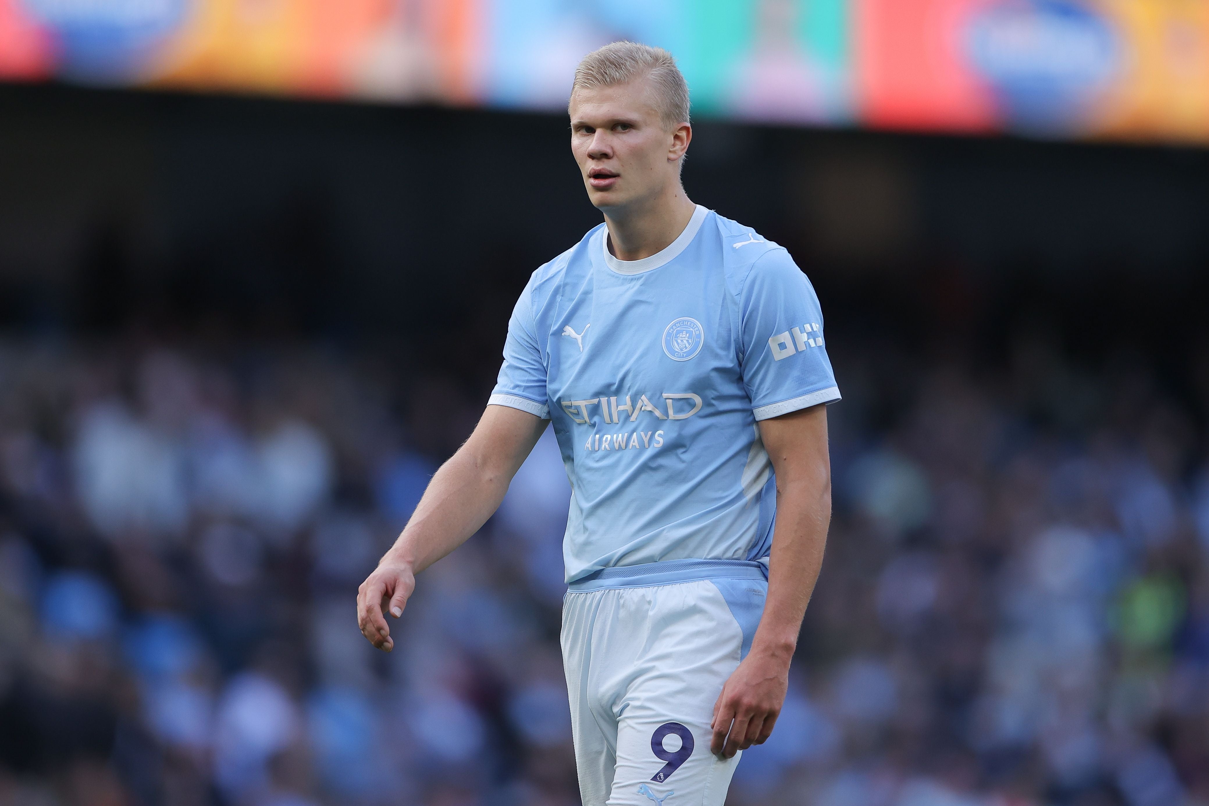 Ein Fußballspieler im hellblauen Manchester-City-Trikot steht auf dem Spielfeld.
