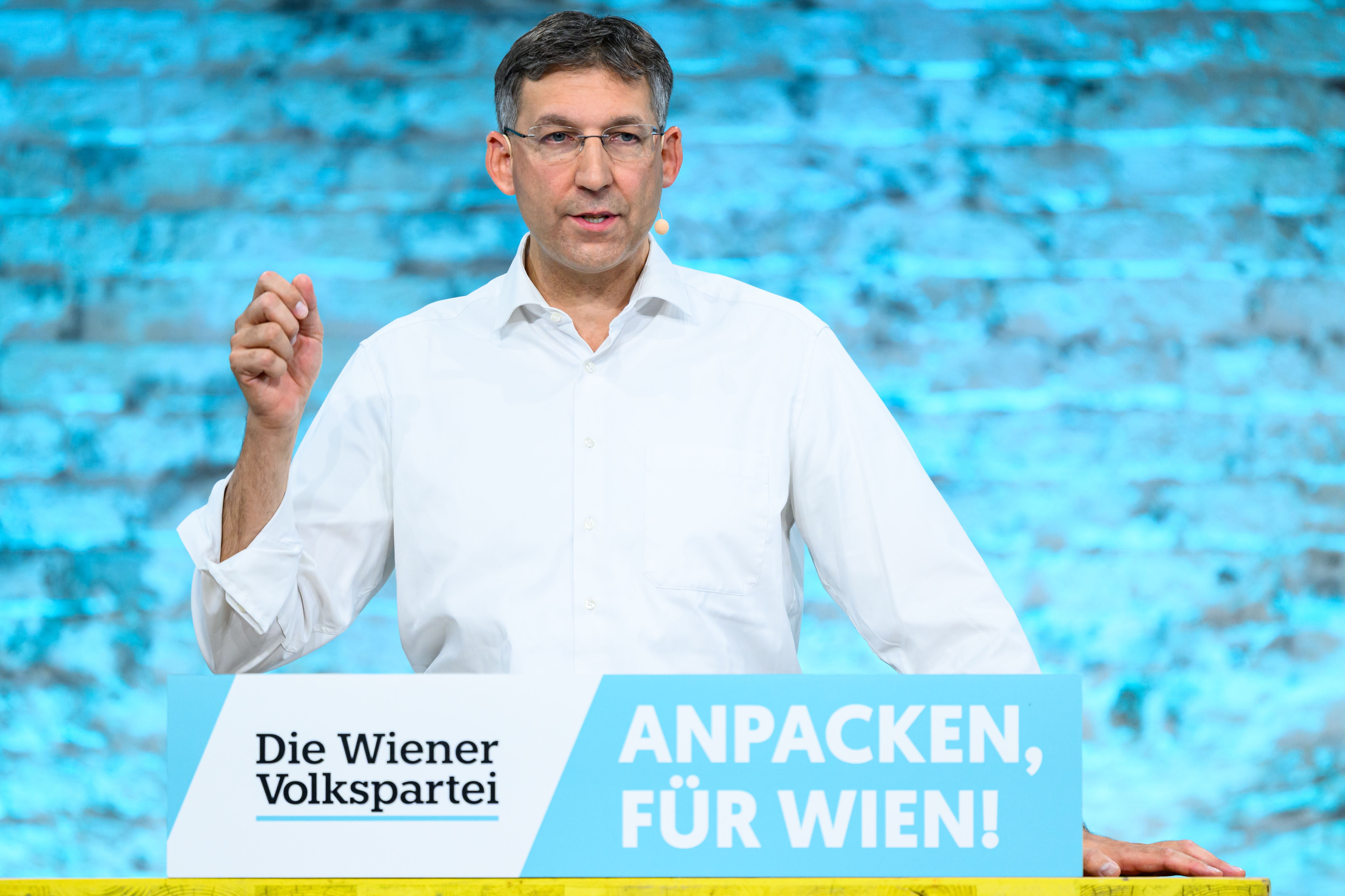 Mann spricht am Rednerpult mit Schild „Die Wiener Volkspartei – Anpacken, für Wien!“.