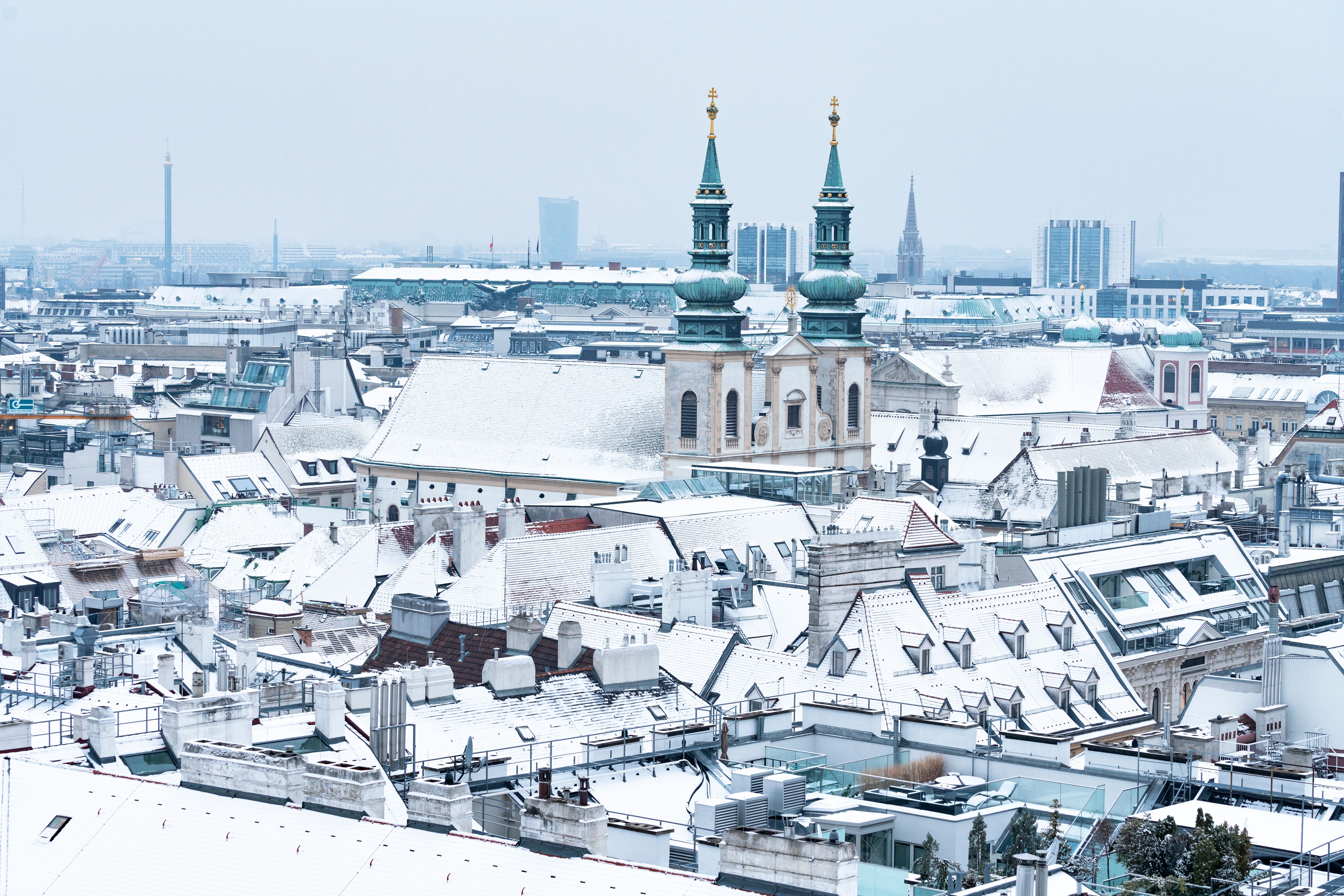 Verschneite Dächer und die Peterskirche in Wien, gesehen vom Stephansdom aus.