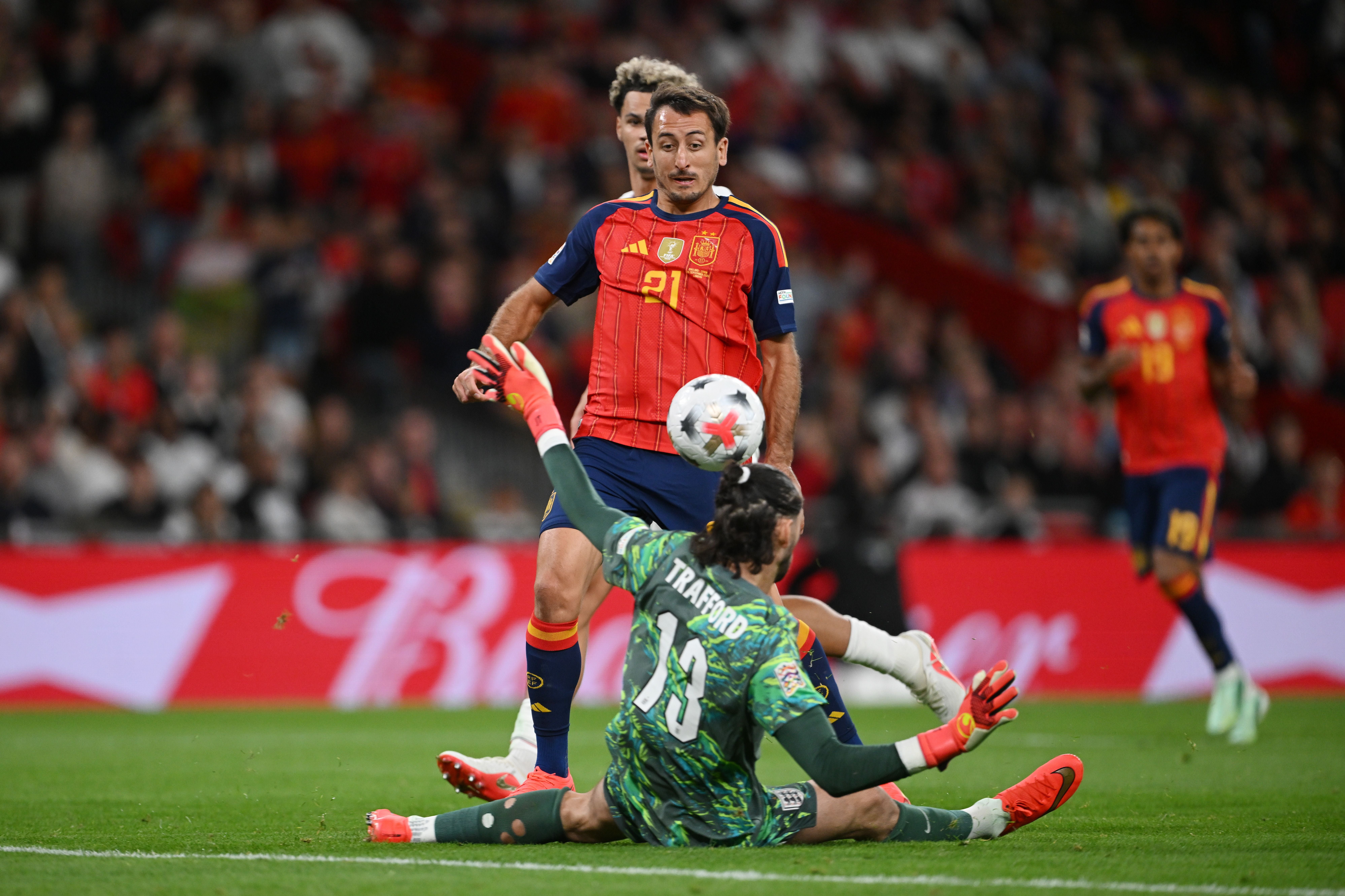 Ein spanischer Fußballspieler trifft gegen Englands Torwart in einem Stadion.