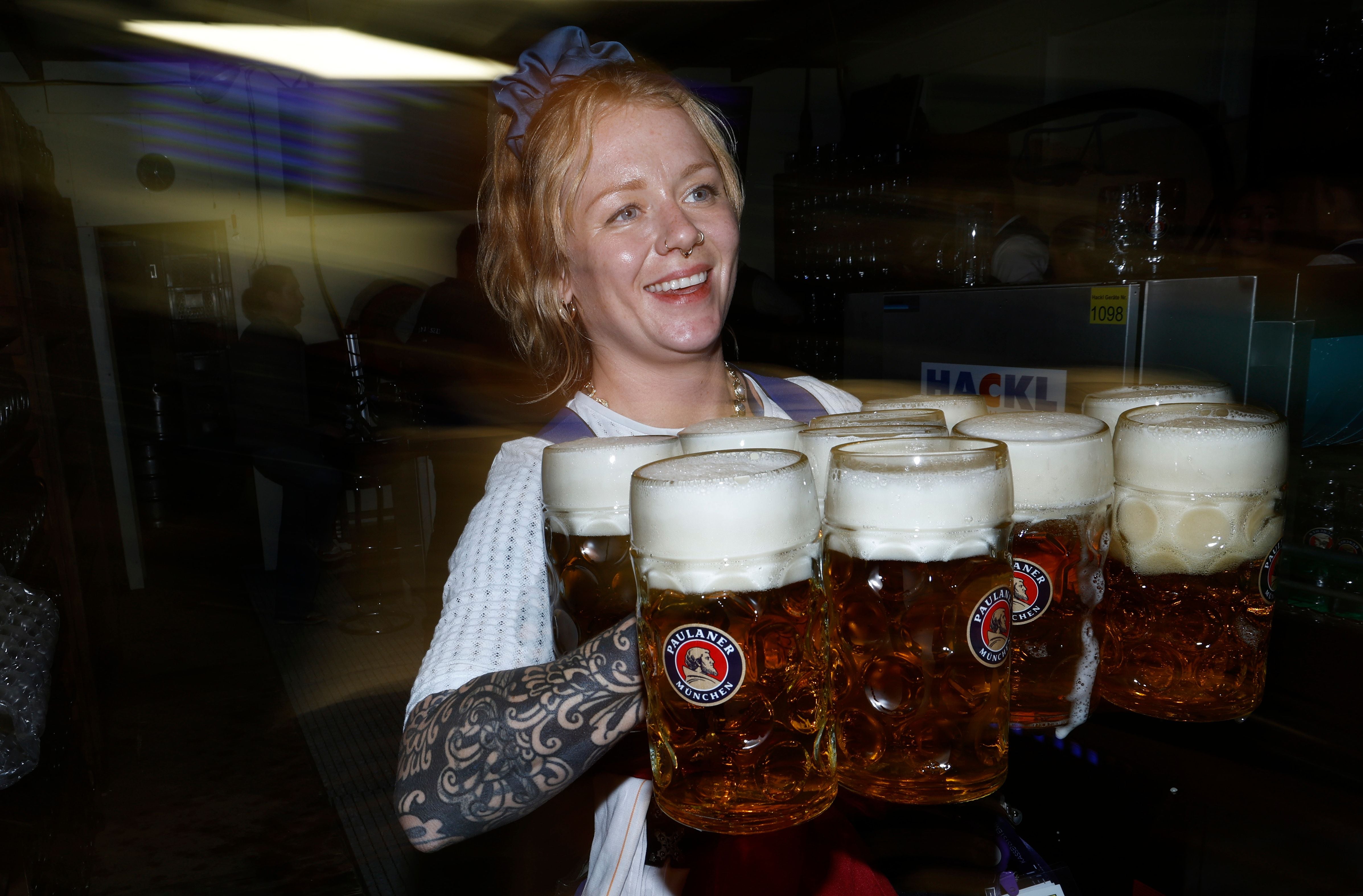 Eine Kellnerin trägt mehrere Maß Bier am ersten Tag des Oktoberfestes in München.