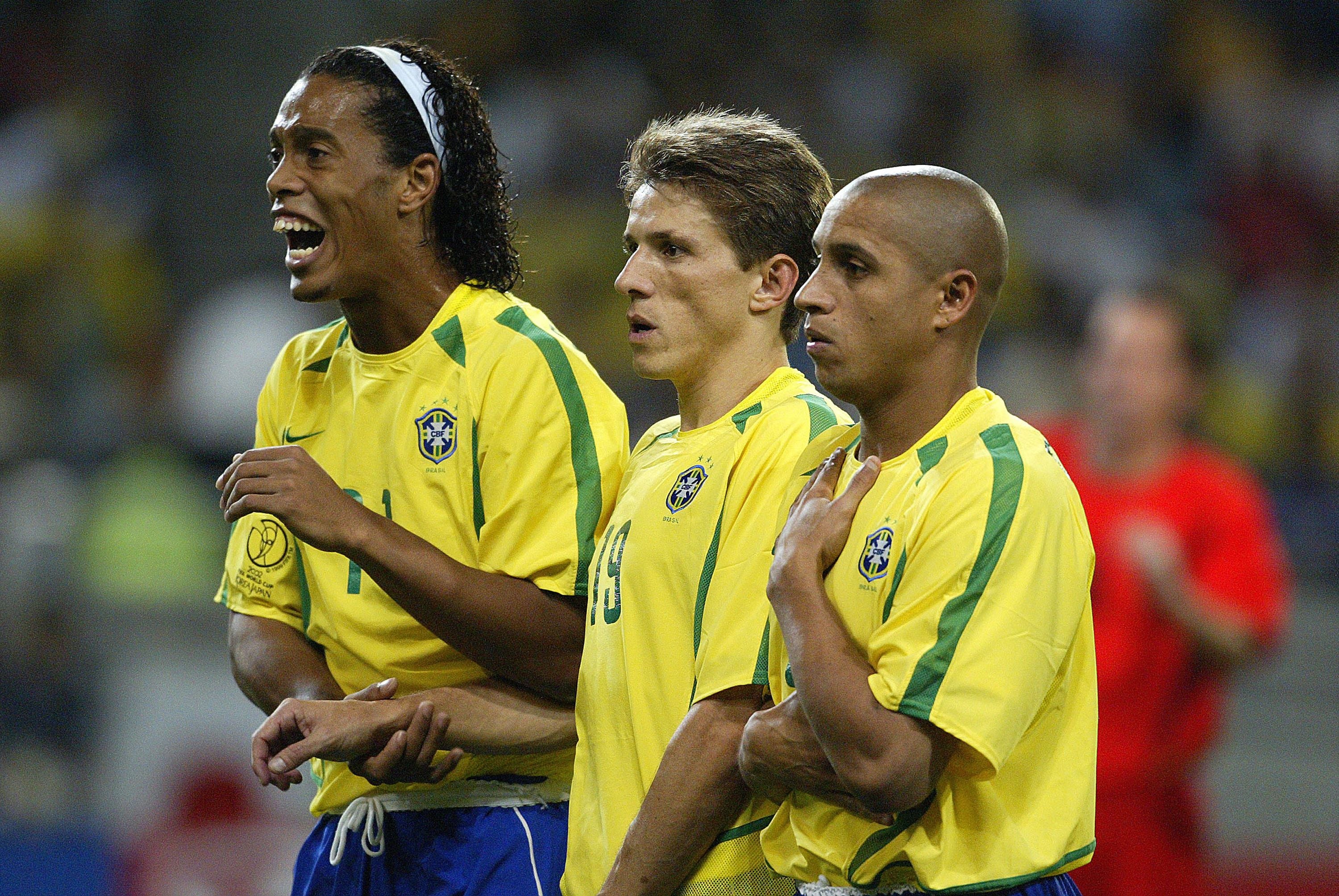 Drei brasilianische Fußballspieler stehen in der Mauer während eines Spiels.