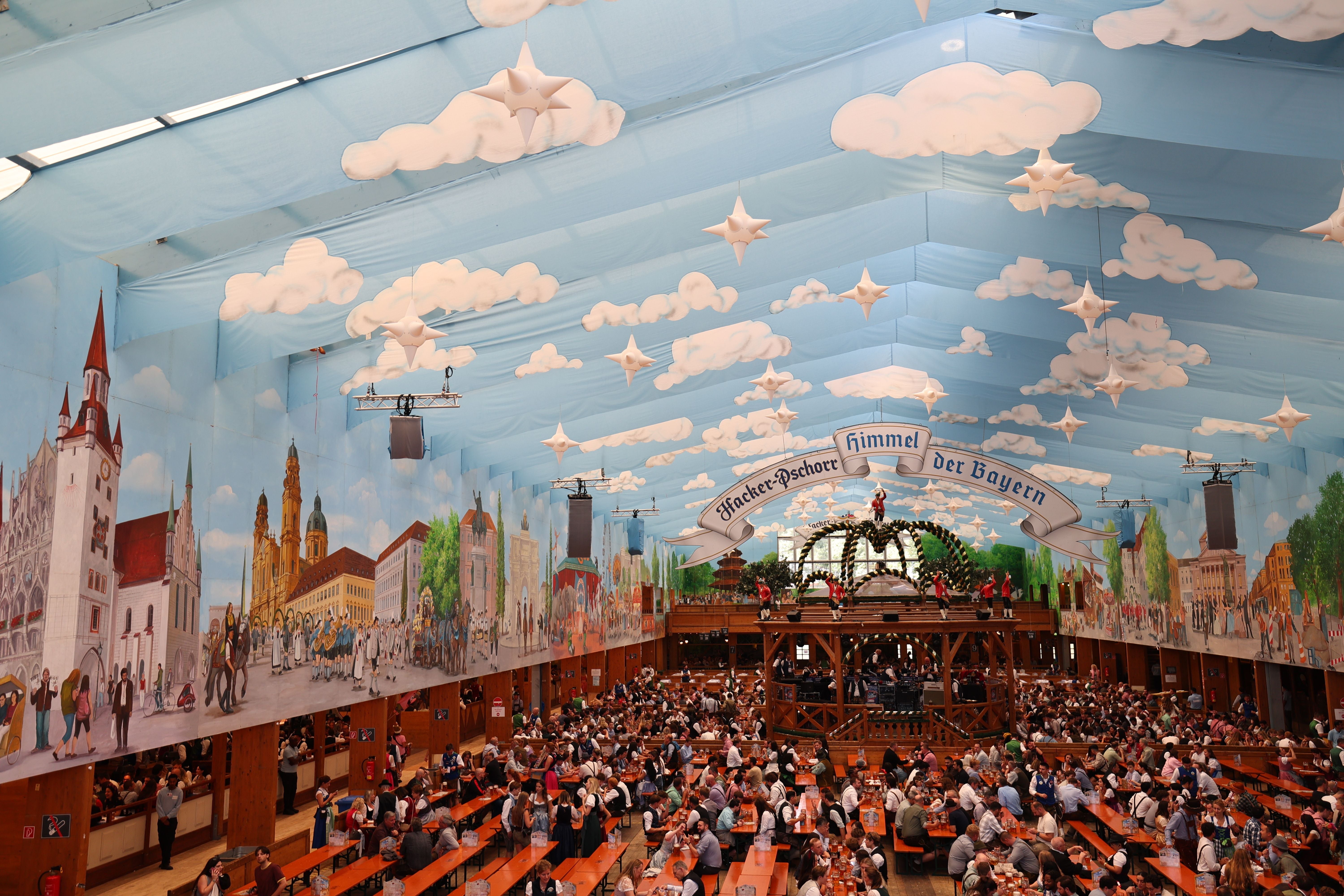 Menschen feiern im festlich geschmückten Hacker-Pschorr-Zelt beim Münchner Oktoberfest.