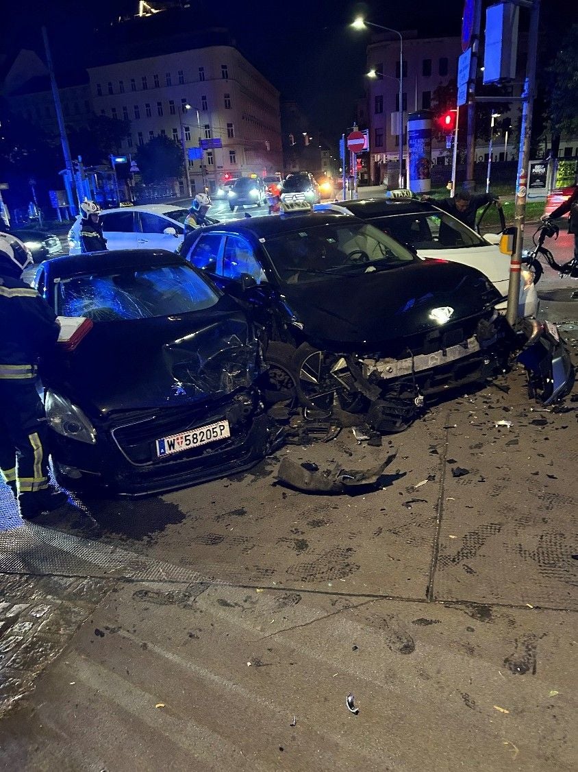 Zwei stark beschädigte Autos nach einem nächtlichen Unfall, Rettungskräfte vor Ort.