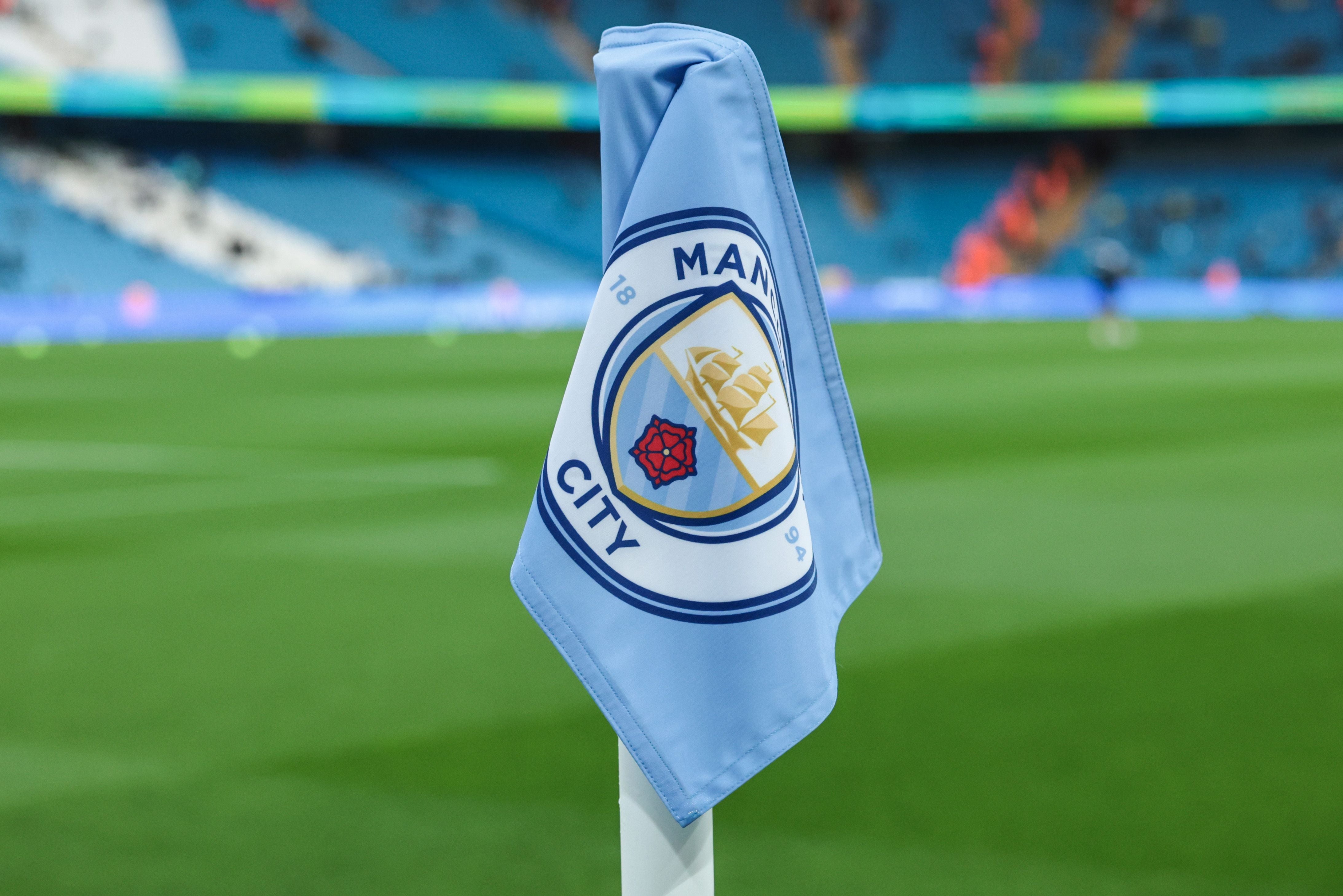 Ecke-Fahne mit Manchester City Logo im Etihad Stadium, Grasfeld im Hintergrund.