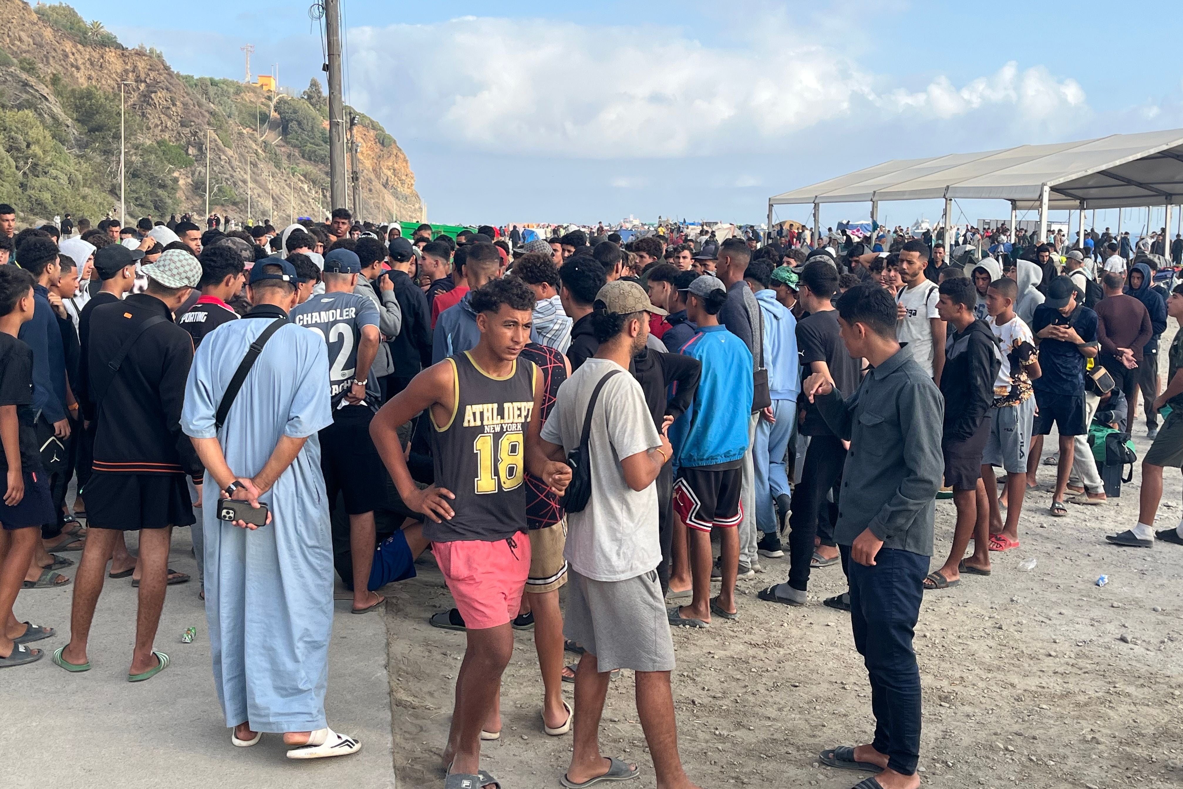 Viele Menschen stehen dicht gedrängt im Freien auf einer Esplanade bei Ceuta, Spanien.