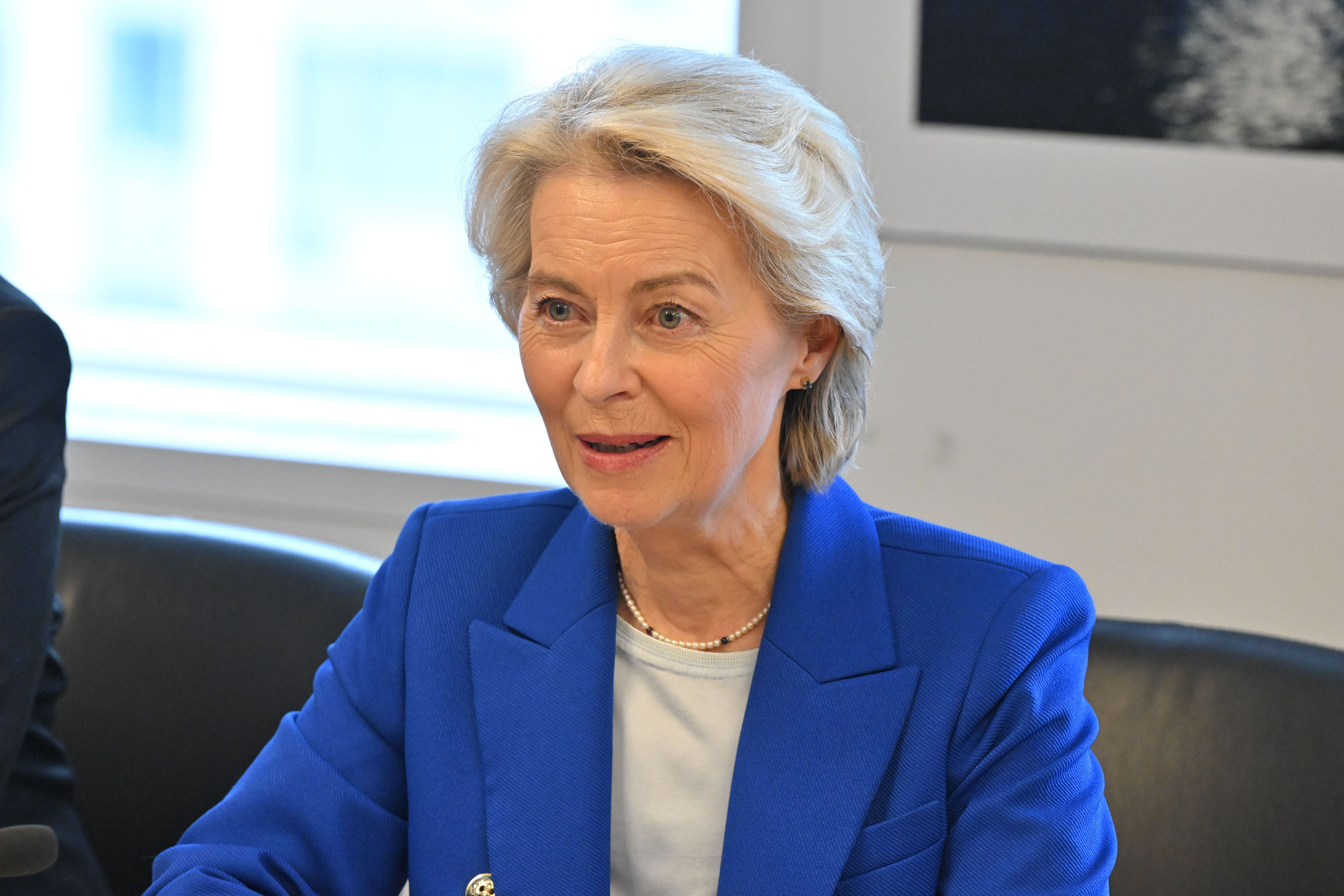 Frau mit blondem Haar im blauen Blazer bei einem Treffen in einem modernen Büro.