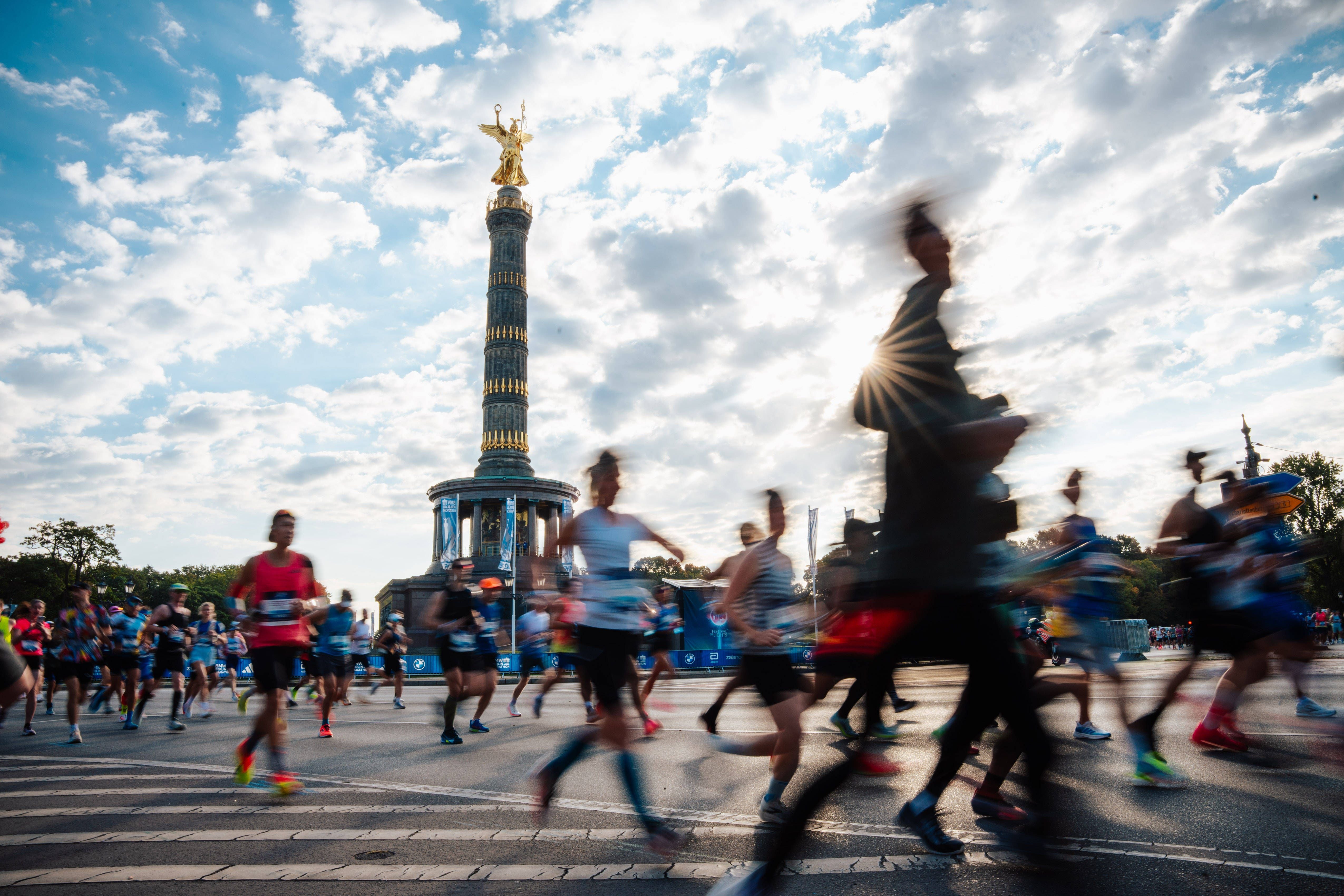 Läufer beim Berlin-Marathon 2026 mit der Siegessäule im Hintergrund und Bewegungsunschärfe.