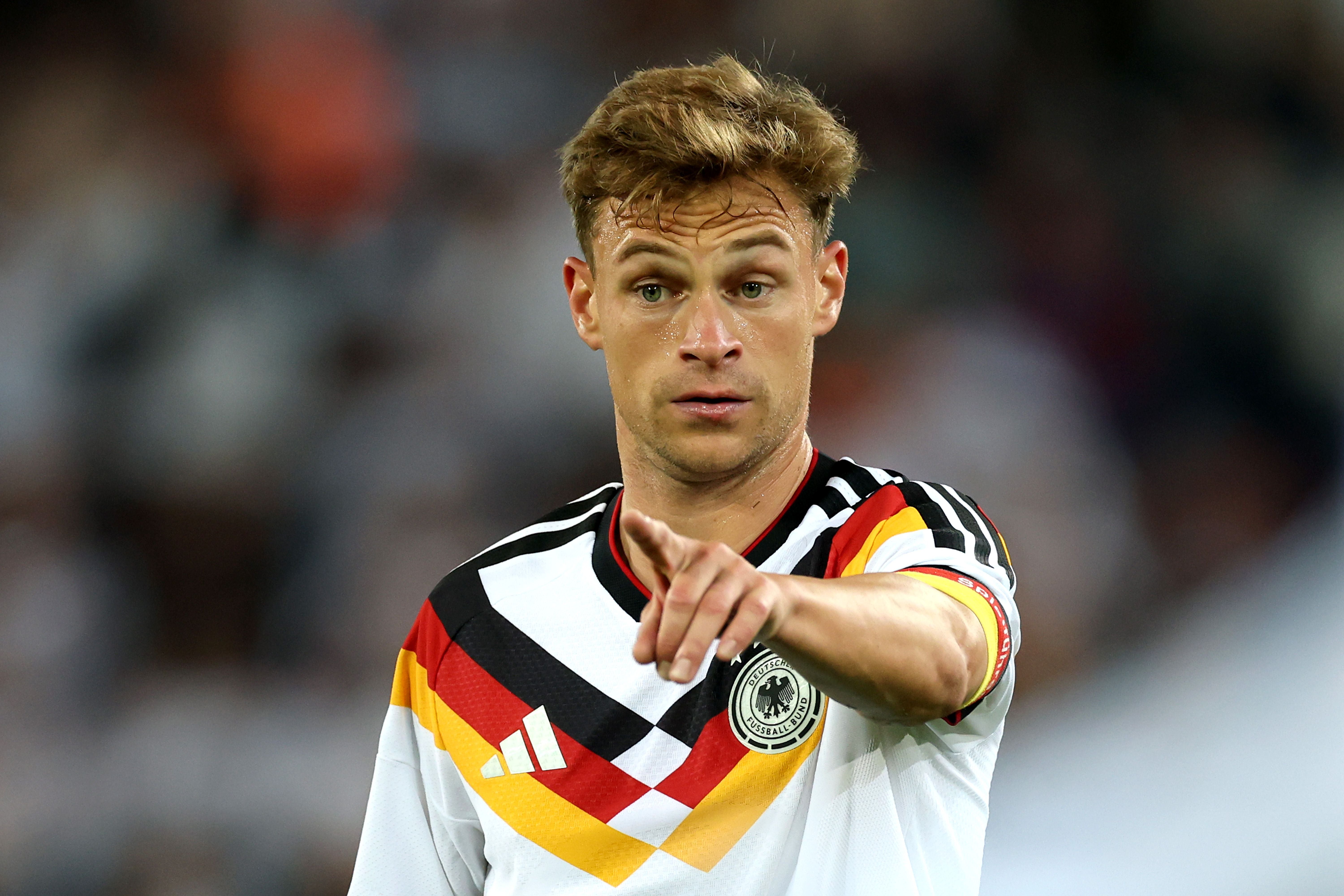 Ein Fußballspieler im Deutschlandtrikot zeigt mit dem Finger nach vorne auf dem Spielfeld.