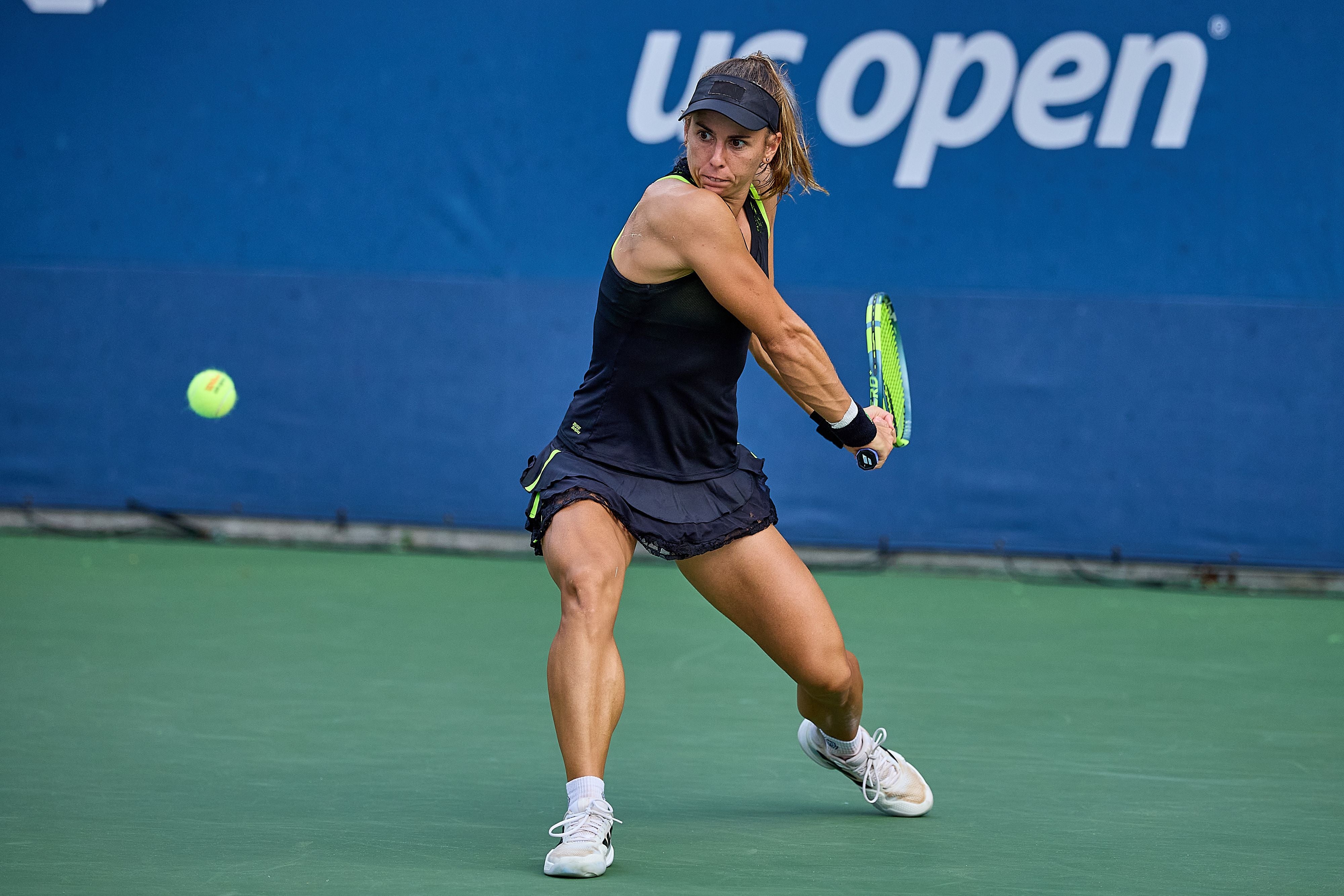 Eine Tennisspielerin schlägt bei den US Open mit einer beidhändigen Rückhand den Ball.