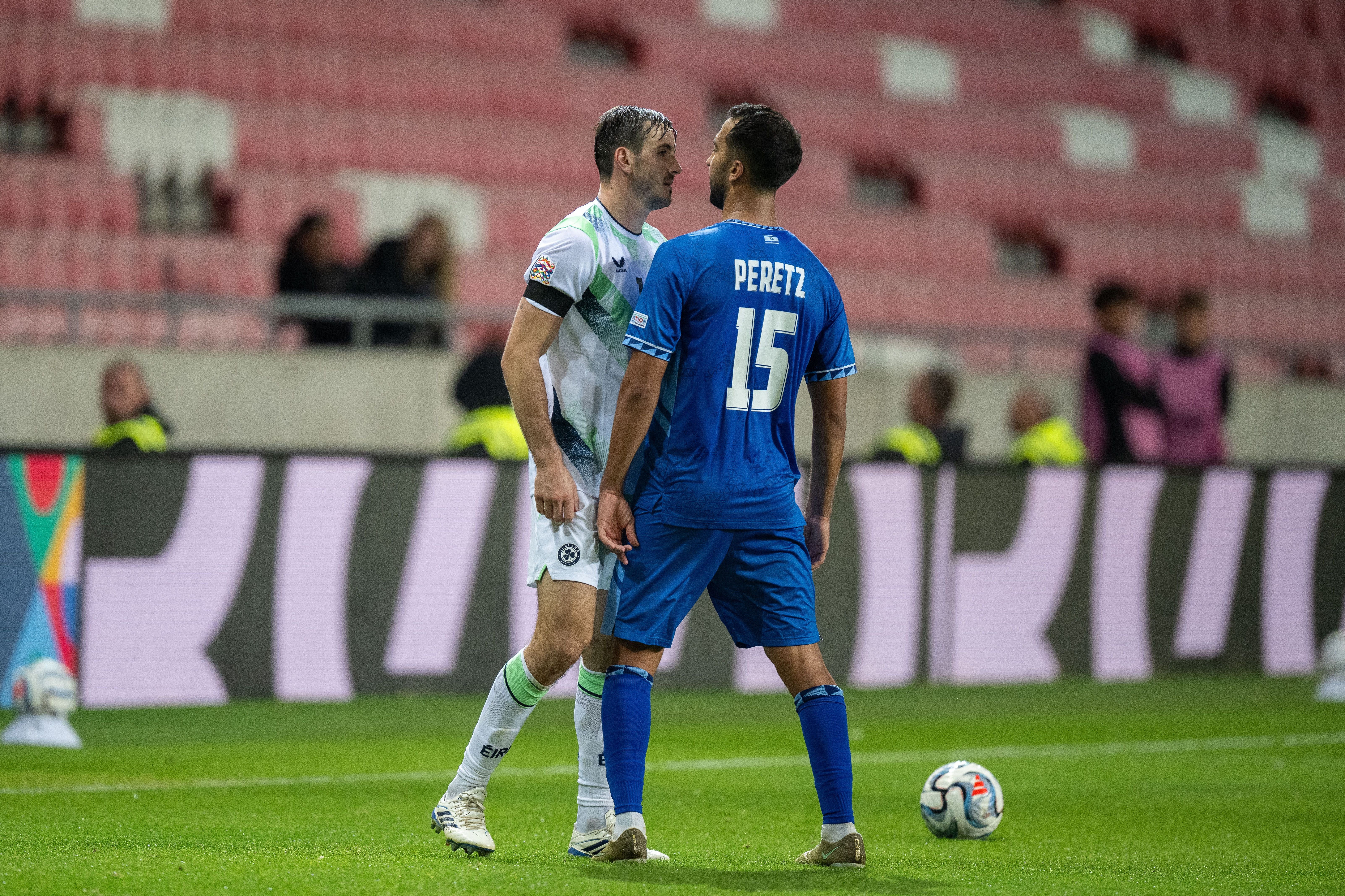 Zwei Fußballspieler stehen sich auf dem Spielfeld konfrontativ gegenüber.