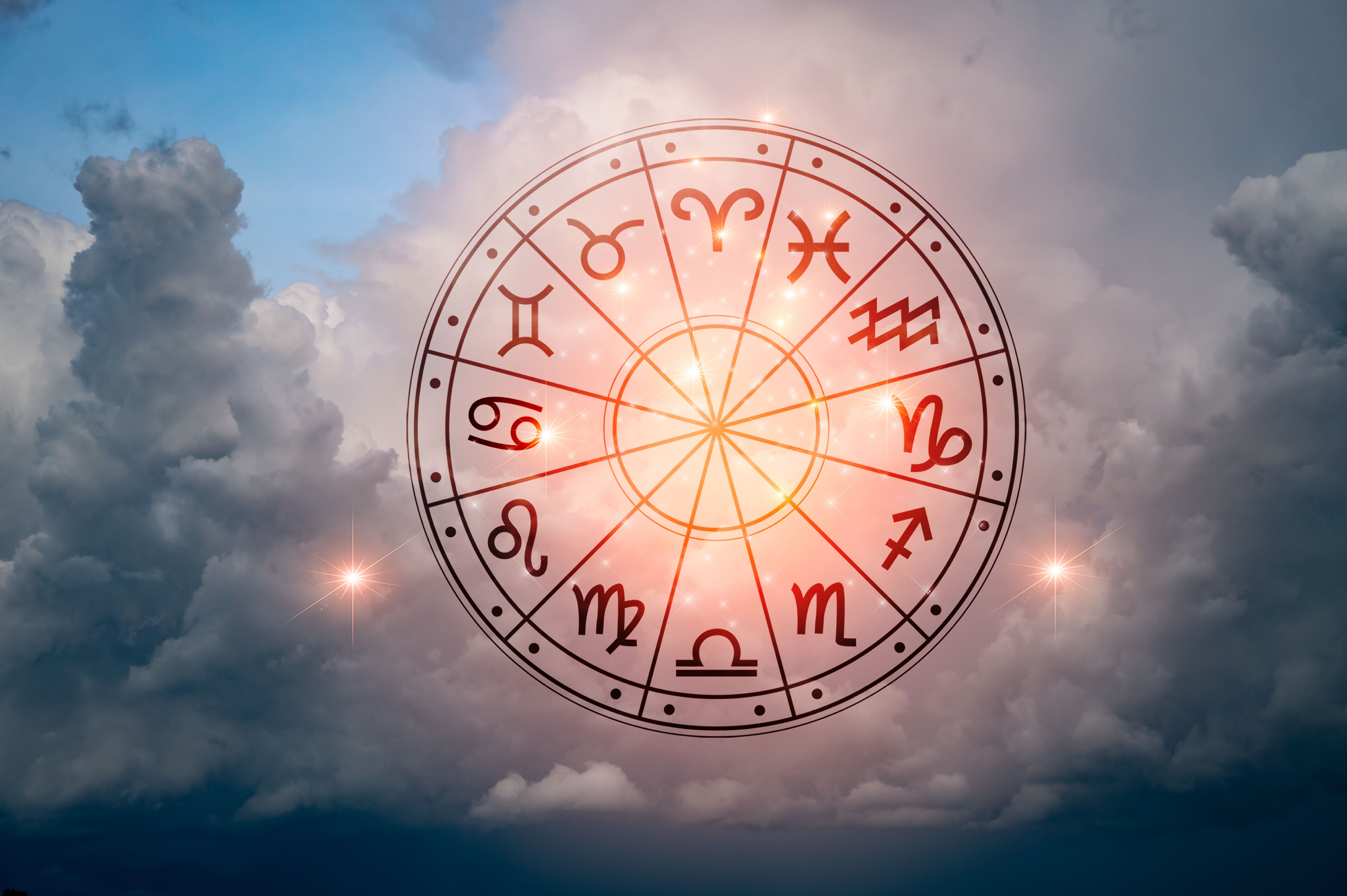 Horoskopkreis mit Tierkreiszeichen schwebt leuchtend vor bewölktem Himmel und Sternen.