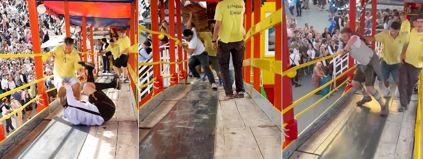Drei Personen rutschen und stolpern auf dem hölzernen Toboggan-Fahrgeschäft auf der Wiesn.