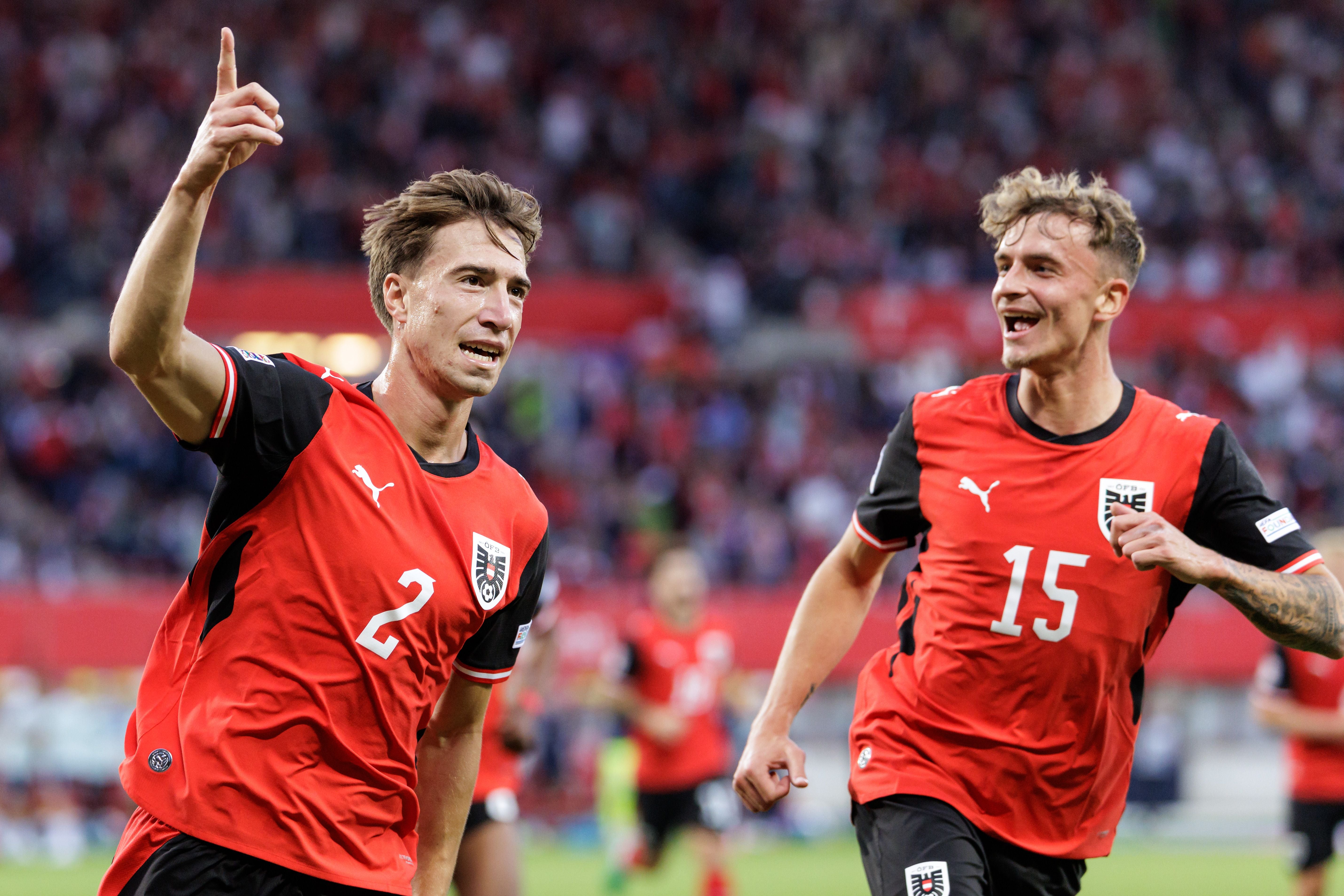 Zwei österreichische Fußballspieler jubeln im Stadion nach einem Torerfolg.