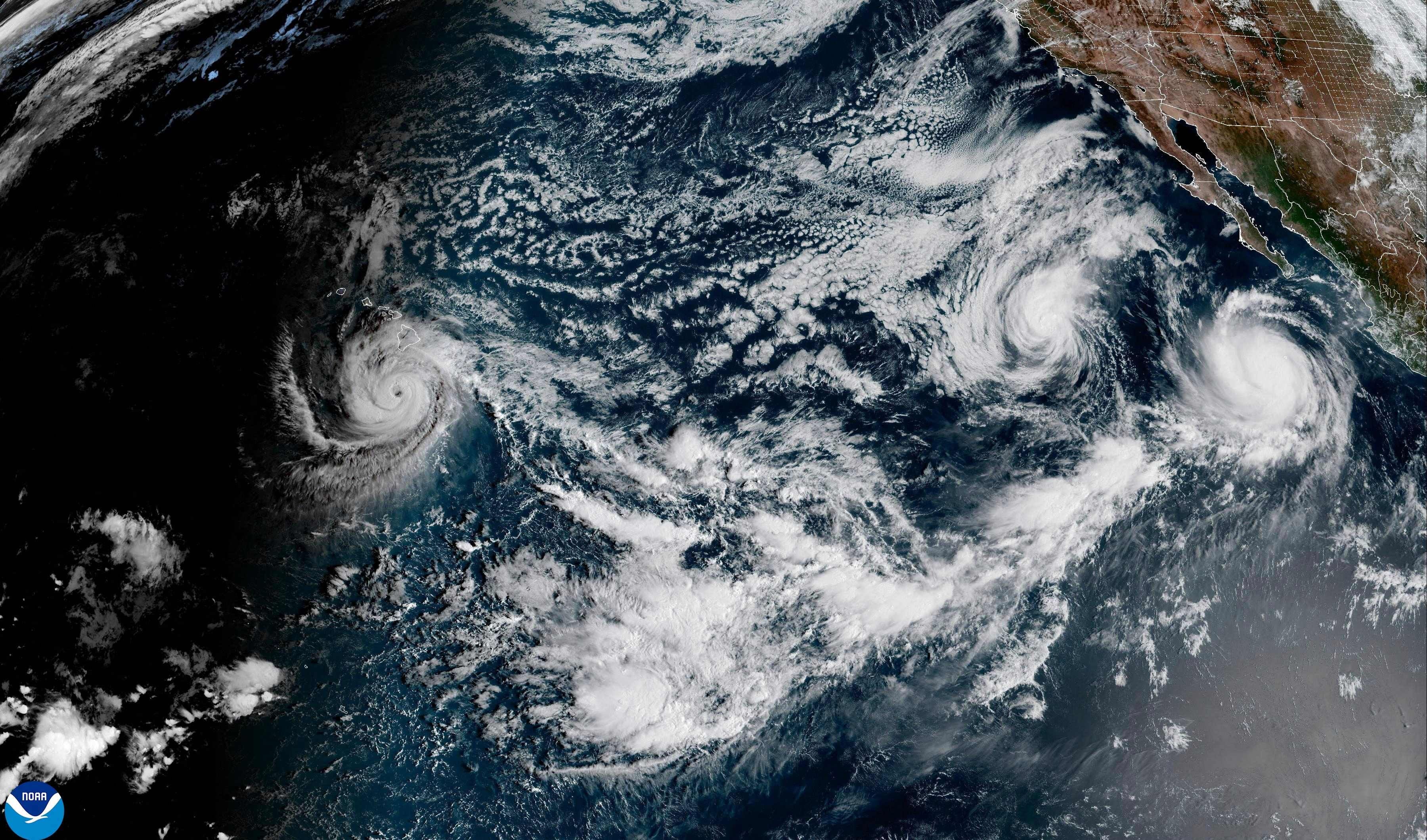 Satellitenbild mit drei Wirbelstürmen über dem Ostpazifik, vor der Küste Mexikos und Hawaii.