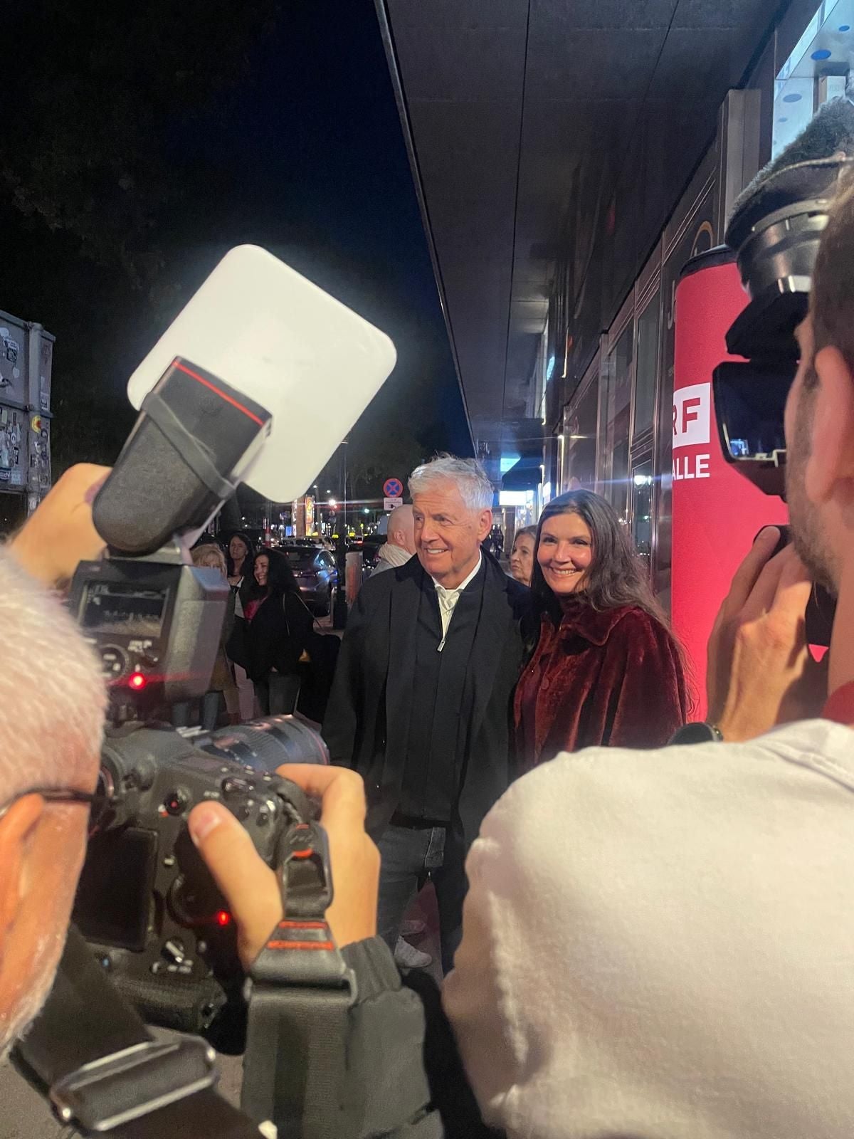 Ein älteres Paar wird bei einer Filmpremiere von Fotografen fotografiert.