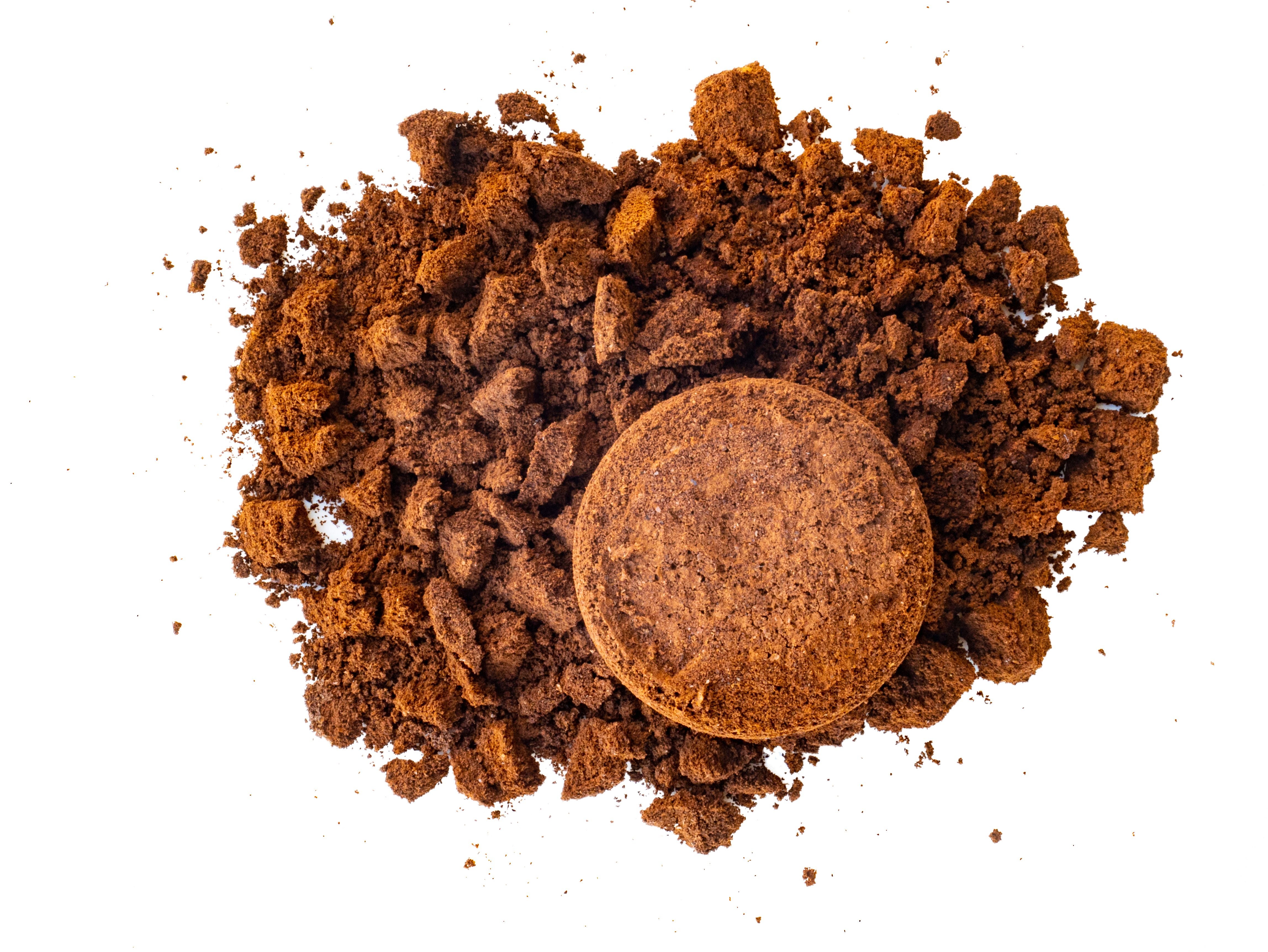 Gebrauchtes Kaffeepulver mit groben und feinen Kaffeepröseln auf weißem Hintergrund.