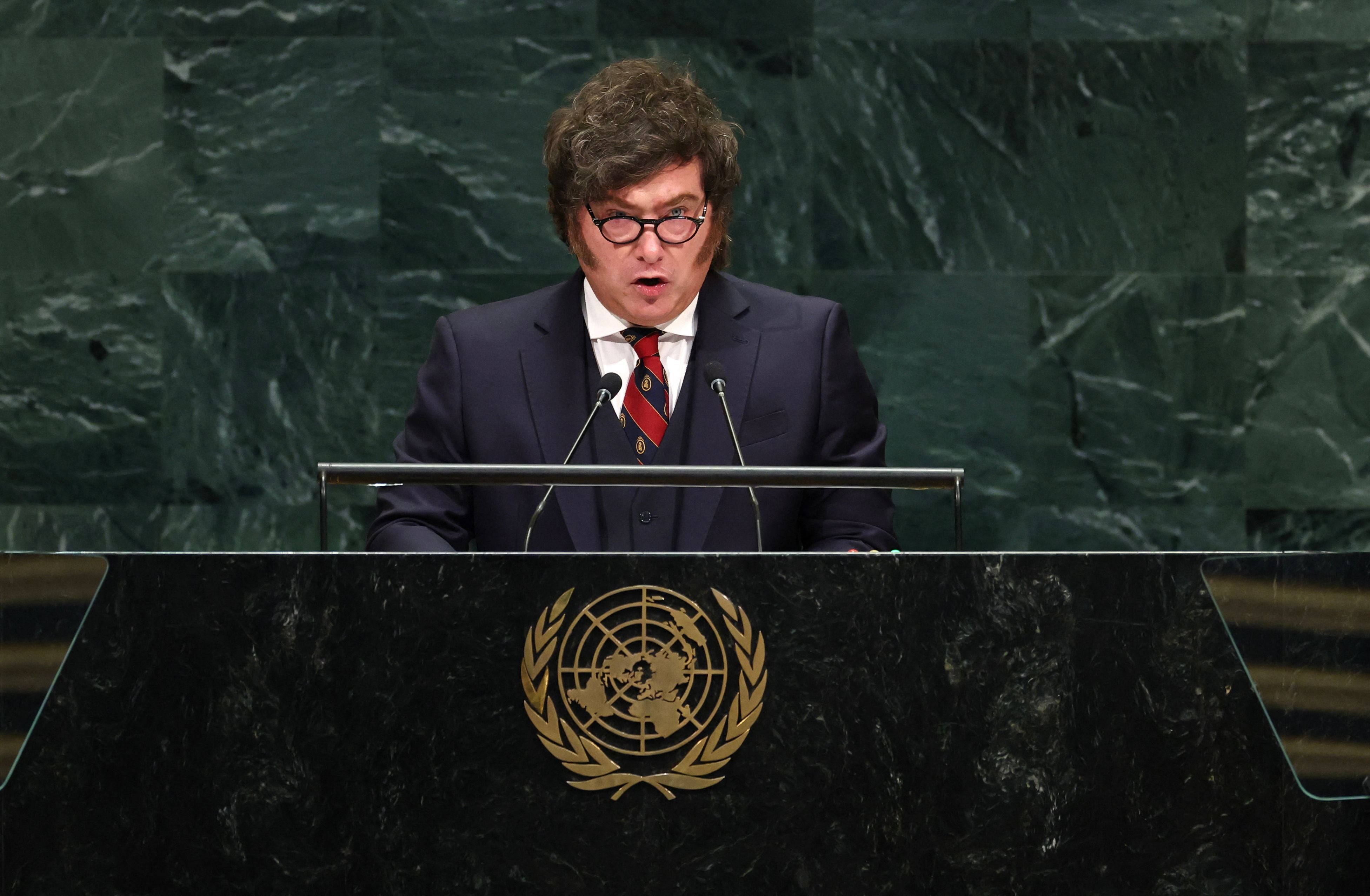 Ein Mann hält eine Rede am UN-Pult mit dem Emblem der Vereinten Nationen im Hintergrund.