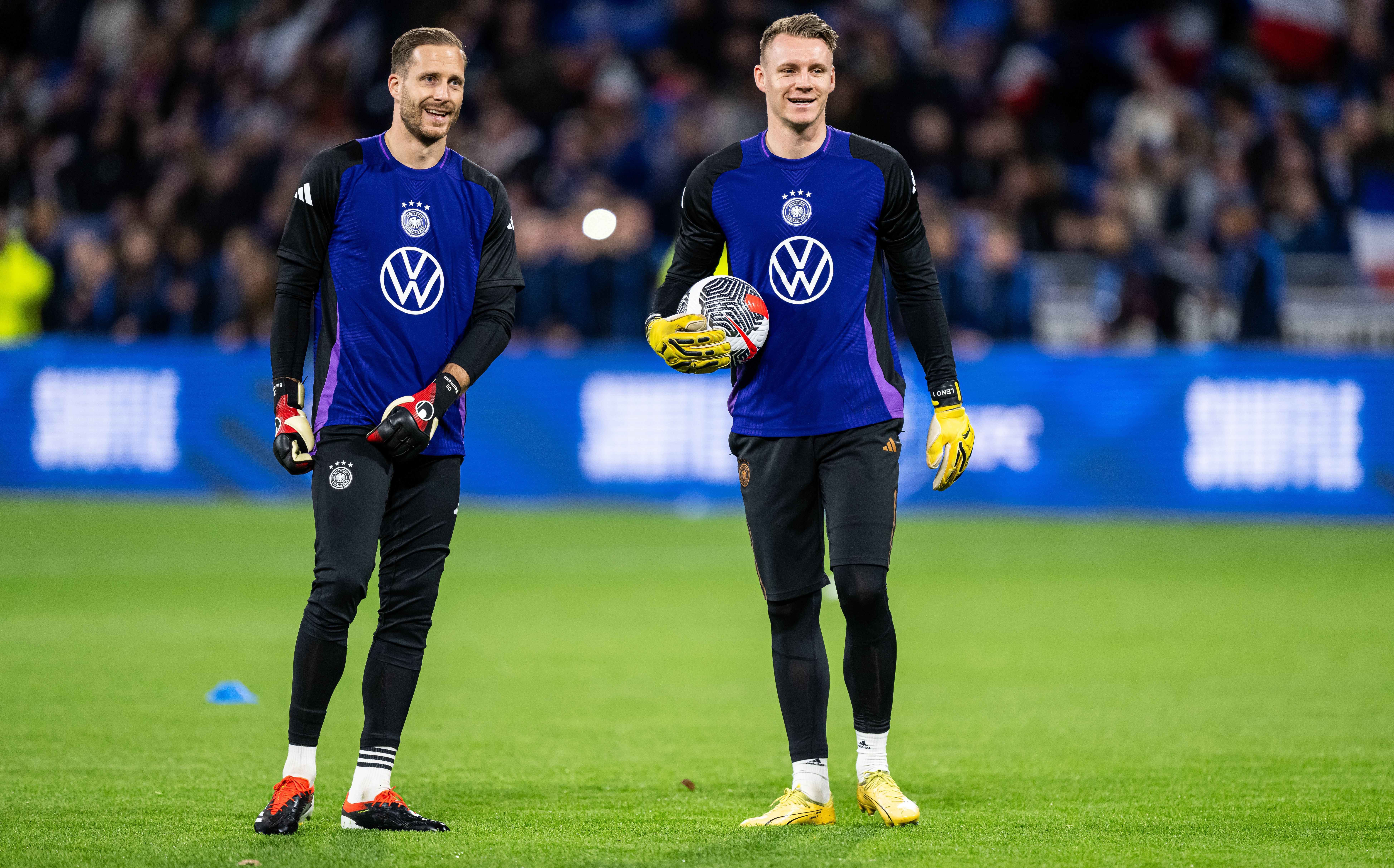 Zwei deutsche Torhüter wärmen sich vor einem Fußballspiel im Stadion auf.