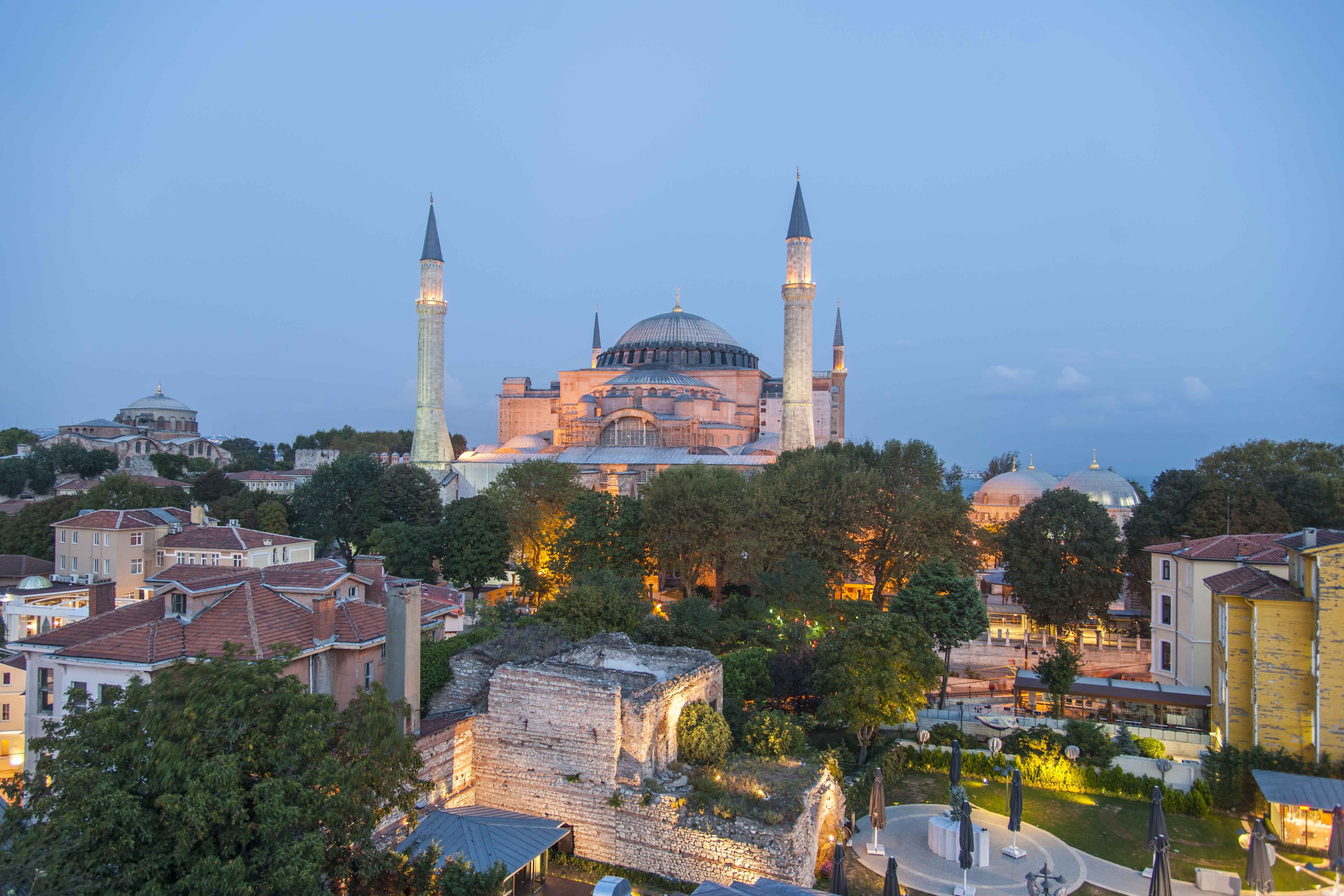 Die Hagia Sophia in Istanbul am Abend, umgeben von Bäumen und Gebäuden.