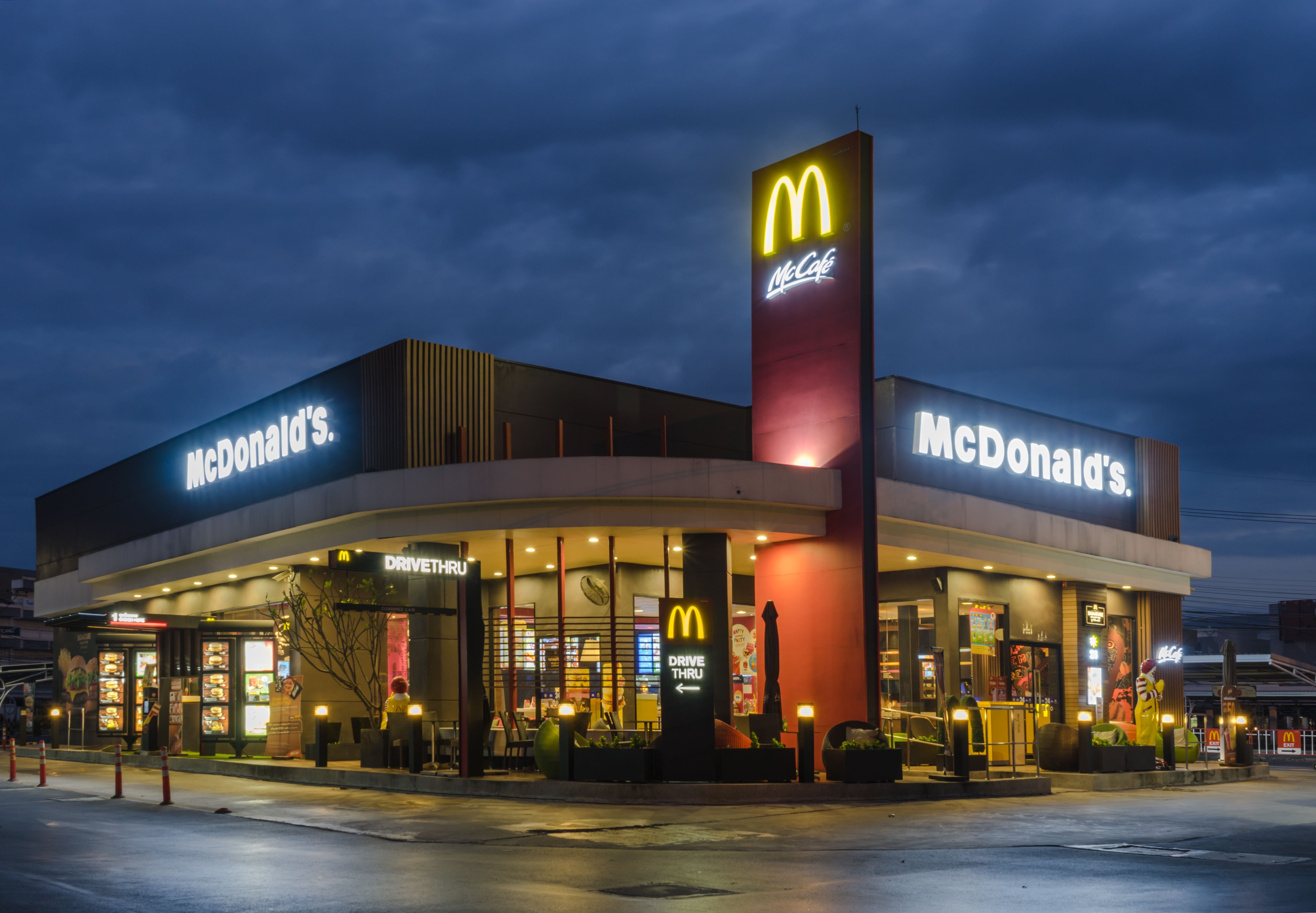 McDonald’s Restaurant mit Drive-Thru bei Nacht in Bangkok, außen beleuchtet.