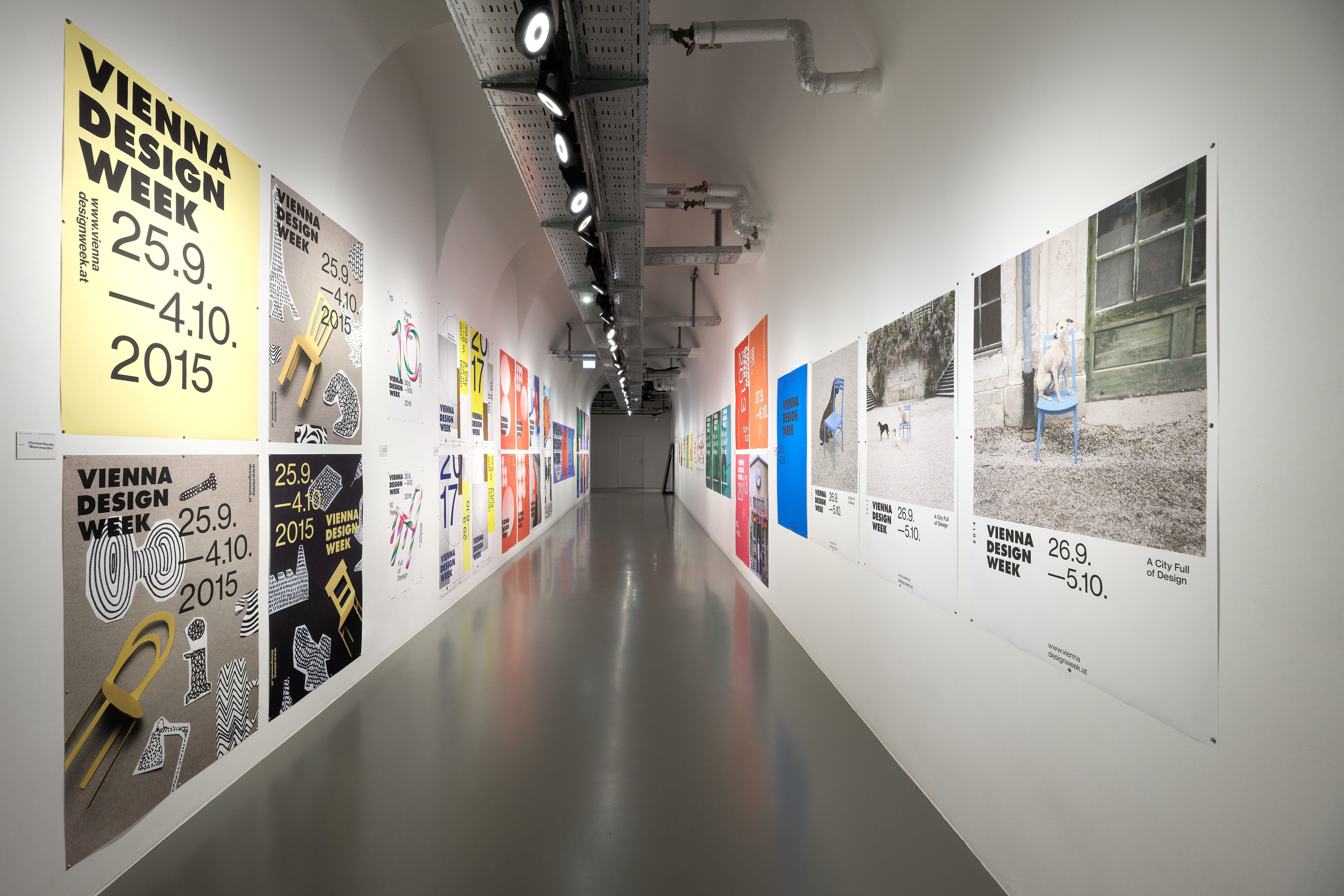 Langer Flur mit Plakaten zur Vienna Design Week an beiden Wänden einer Ausstellung.