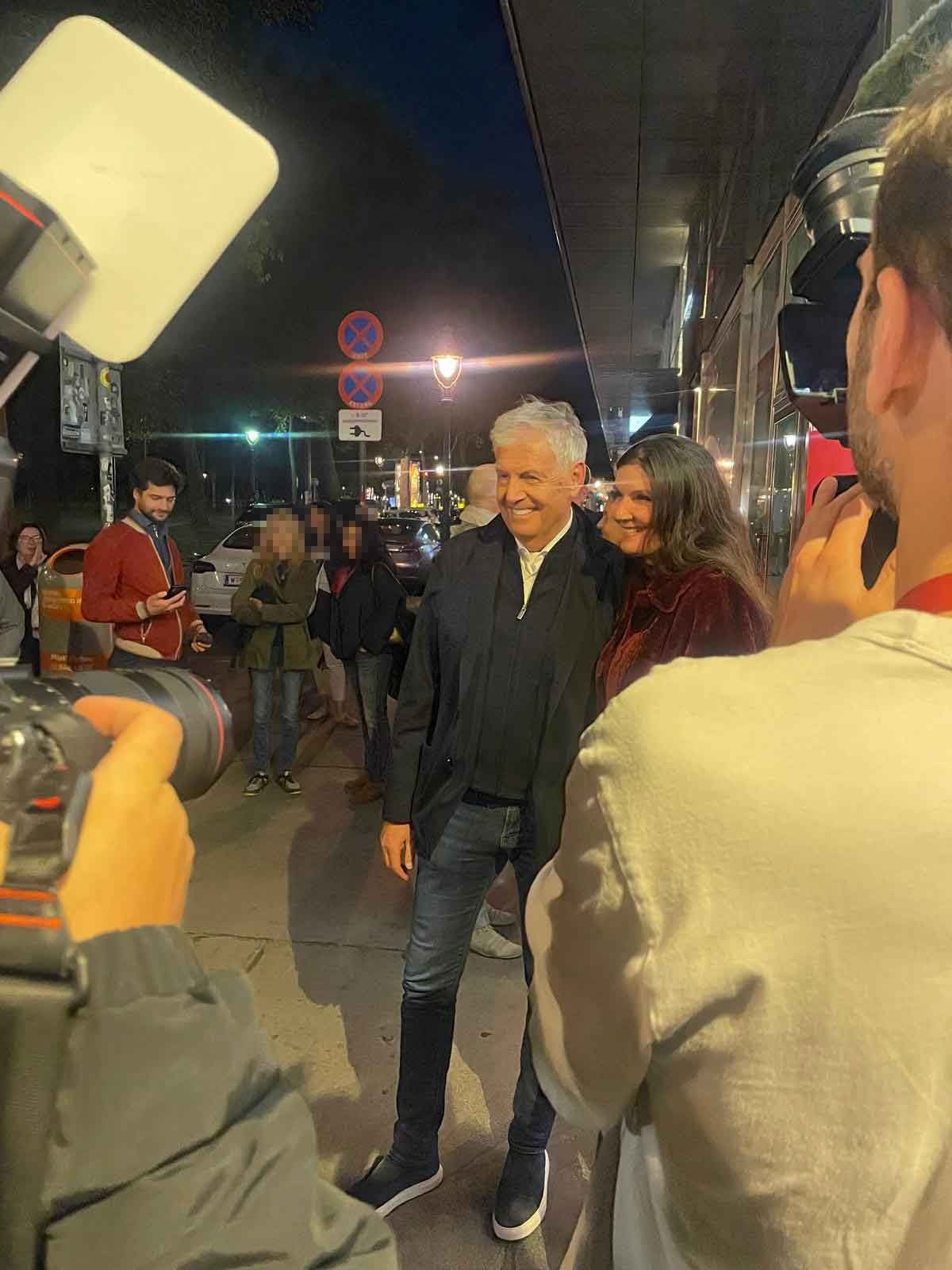 Zeiler posiert bei einer Filmpremiere für ein Foto mit einer Frau, umgeben von Fotografen.