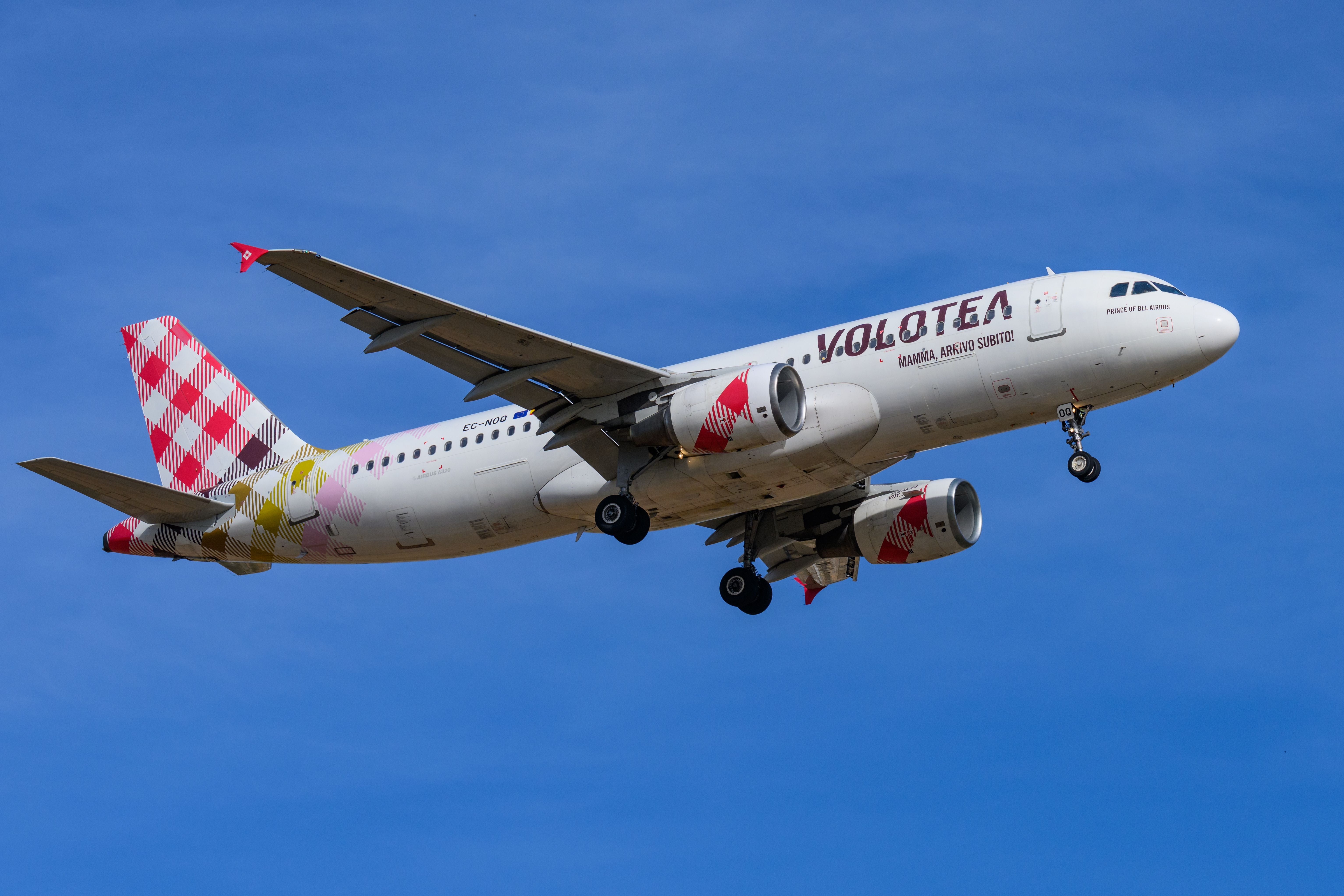 Ein Volotea Airbus A320 landet am Flughafen Palma bei blauem Himmel.