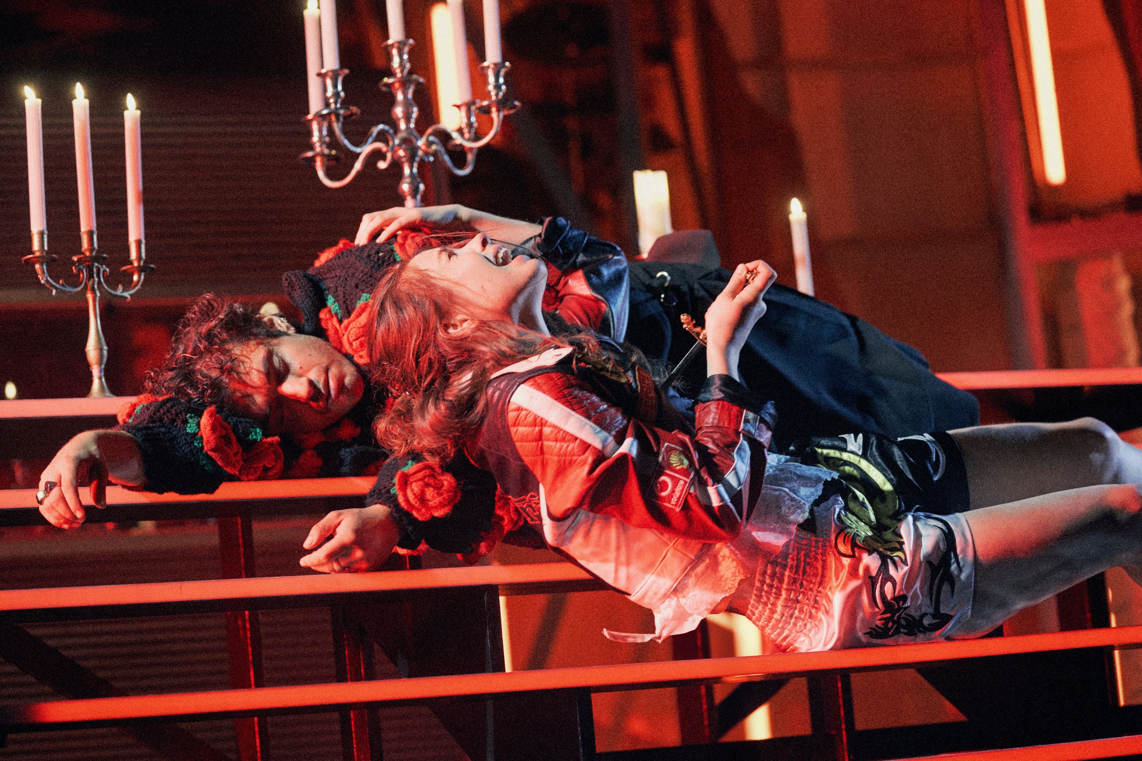 Zwei Schauspieler stellen eine dramatische Szene aus „Romeo und Julia“ auf einer Bühne dar.