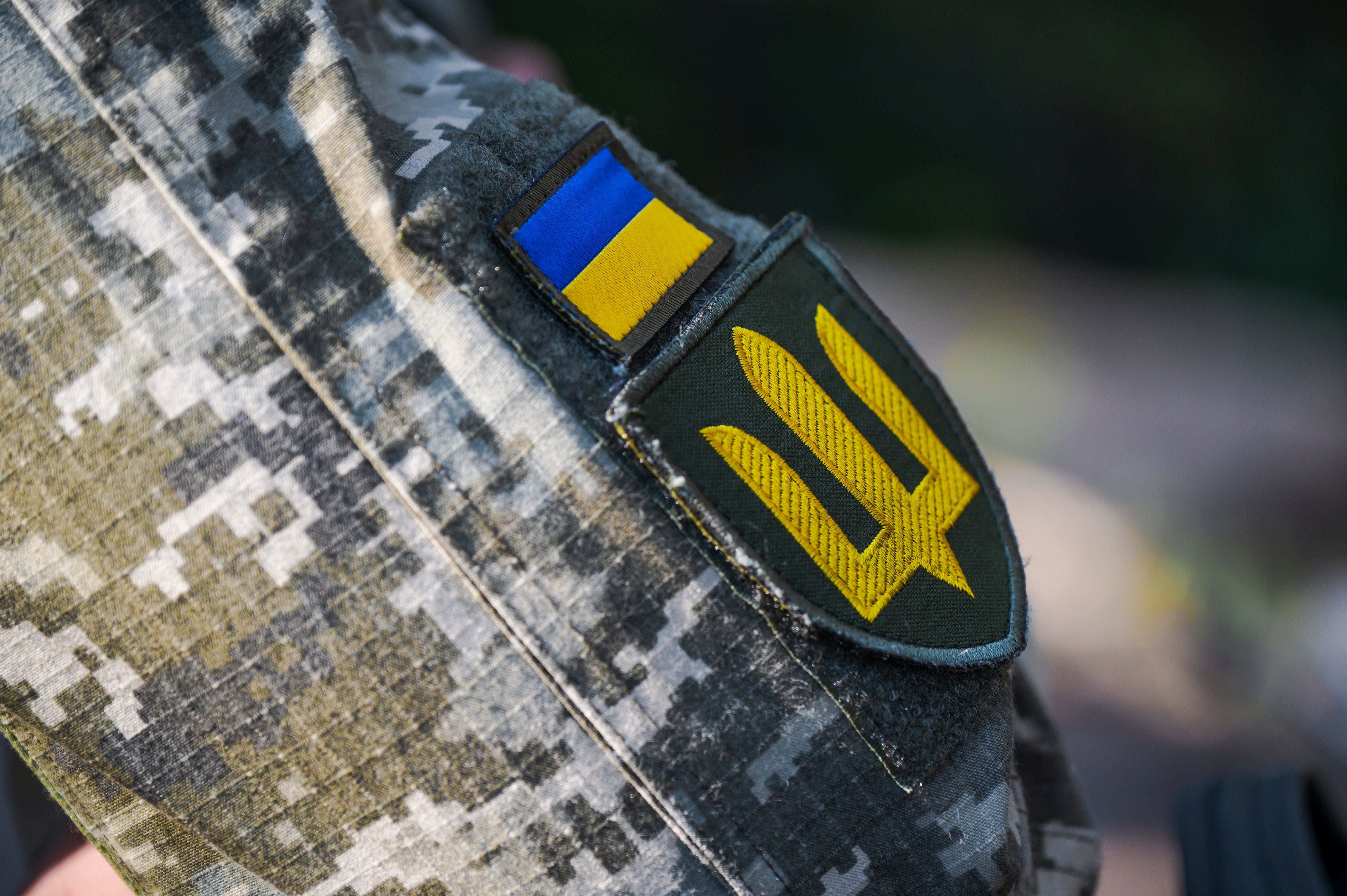 Nahaufnahme einer ukrainischen Tarnuniform mit Flaggen- und Wappenabzeichen am Ärmel.
