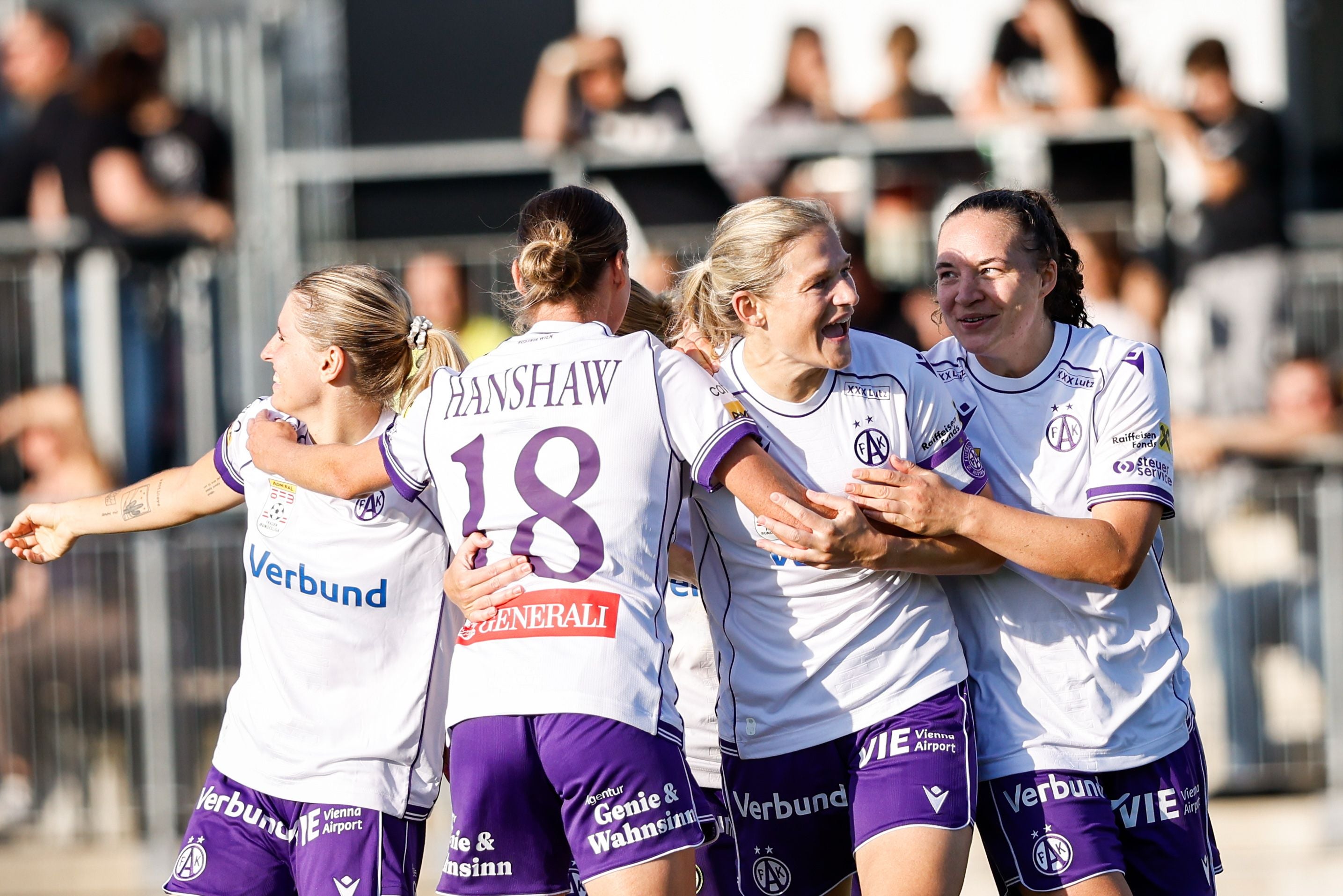 Vier Spielerinnen von FK Austria Wien jubeln gemeinsam auf dem Fußballfeld.