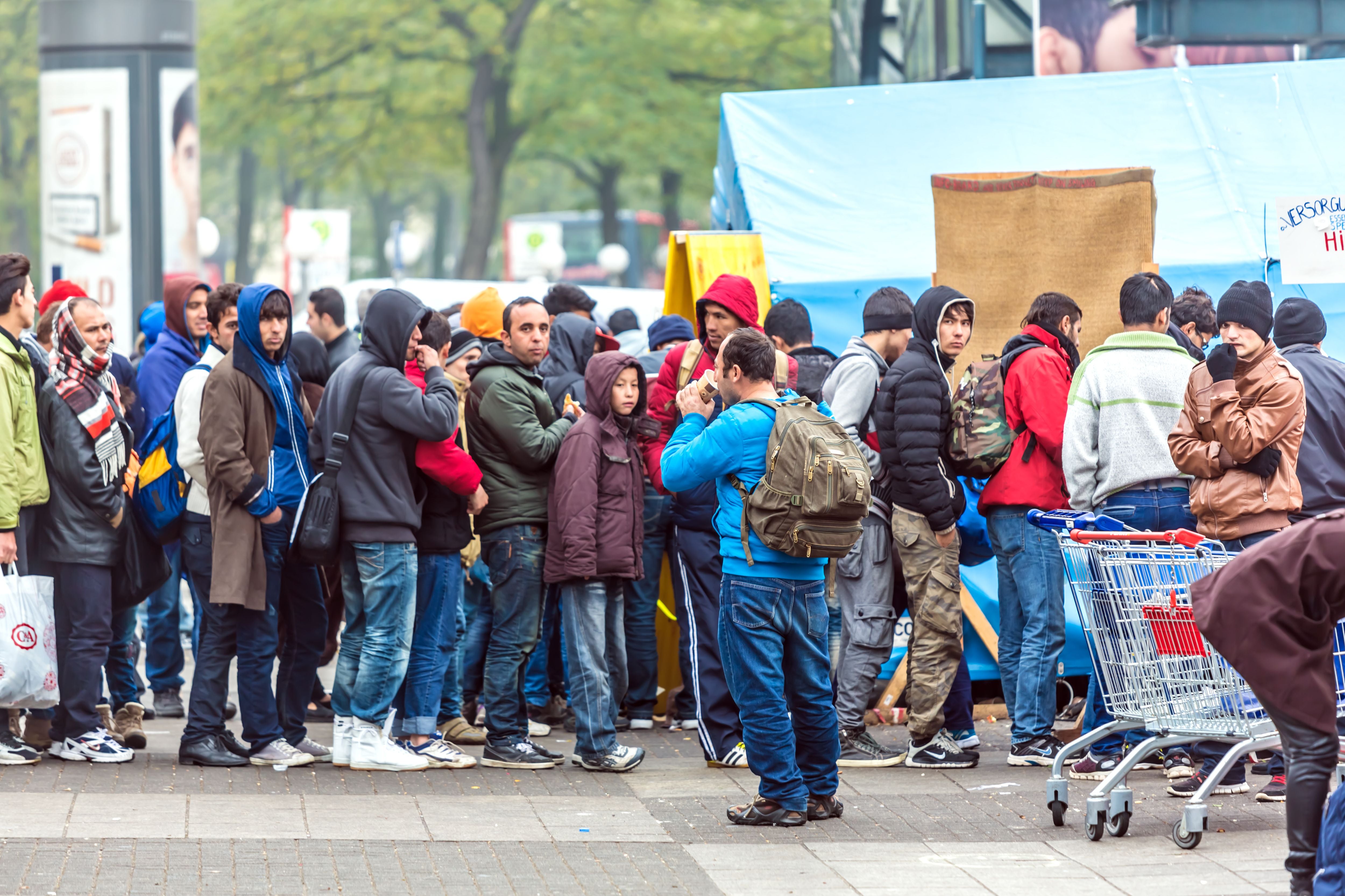 Viele Menschen stehen in einer Schlange vor einem Zelt und warten auf Hilfe in Hamburg.