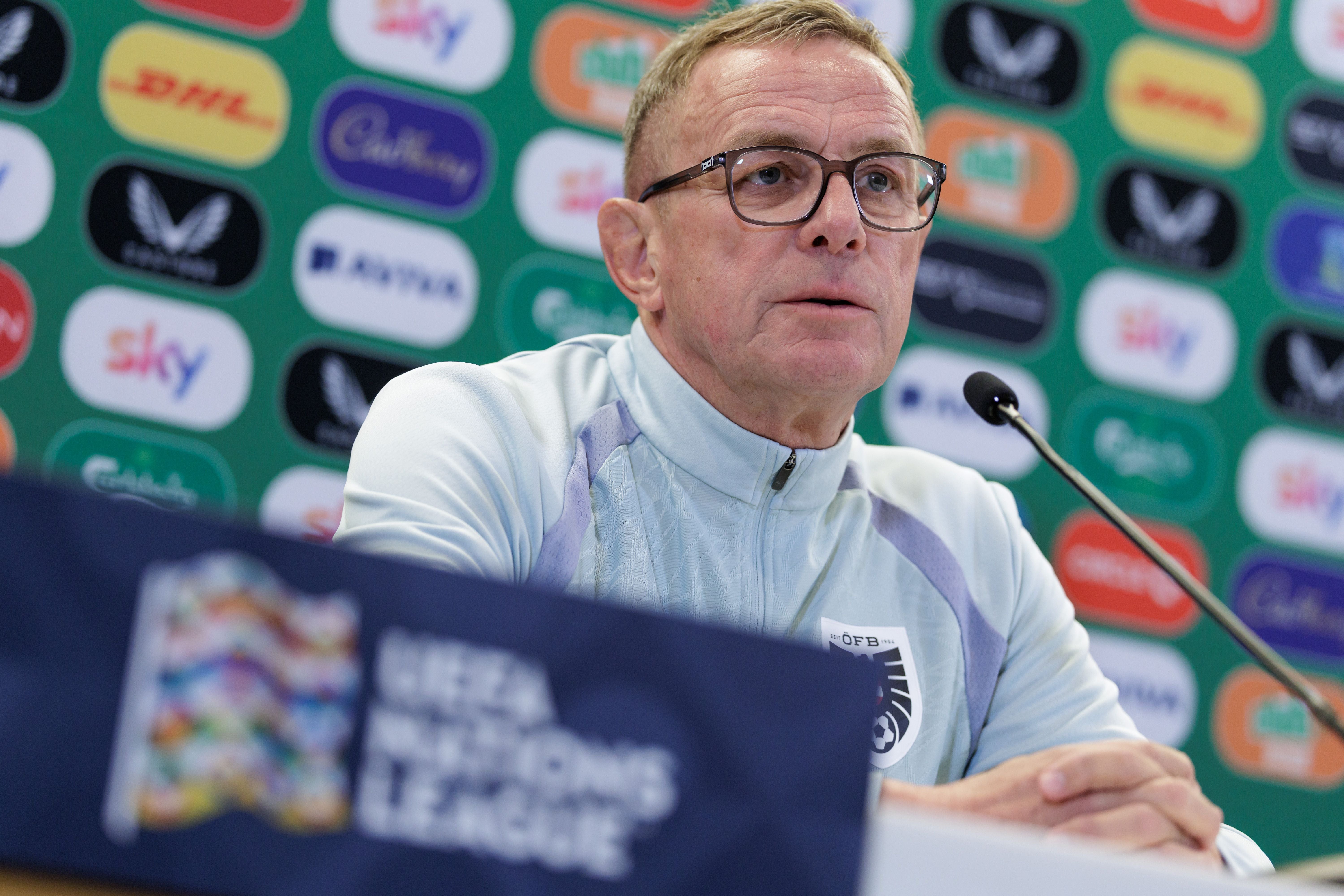 Ein Mann mit Brille spricht bei einer UEFA Nations League Pressekonferenz vor Sponsorenwänden.