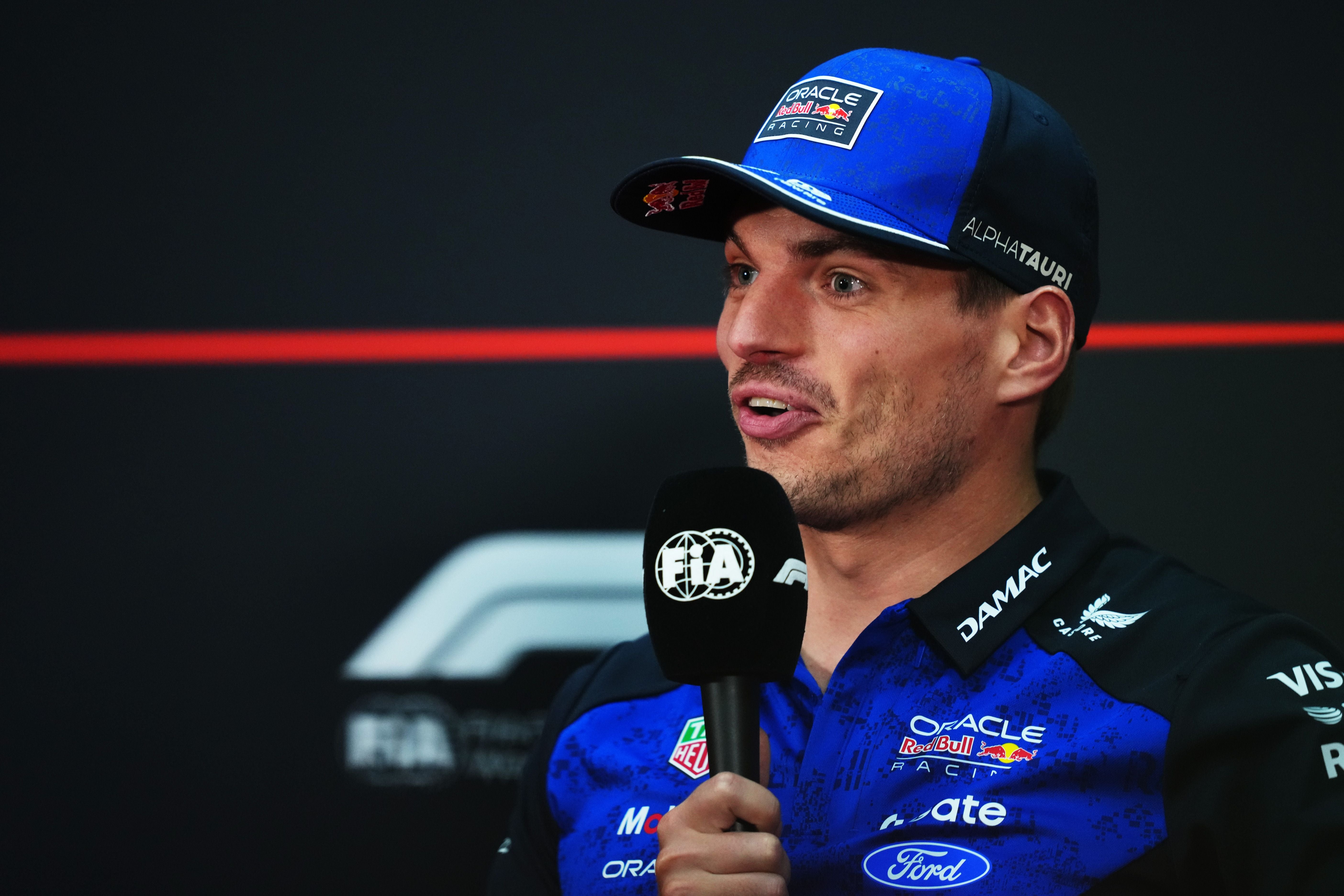 Ein Mann im Red Bull Racing Outfit spricht mit einem FIA-Mikrofon bei einer Pressekonferenz.