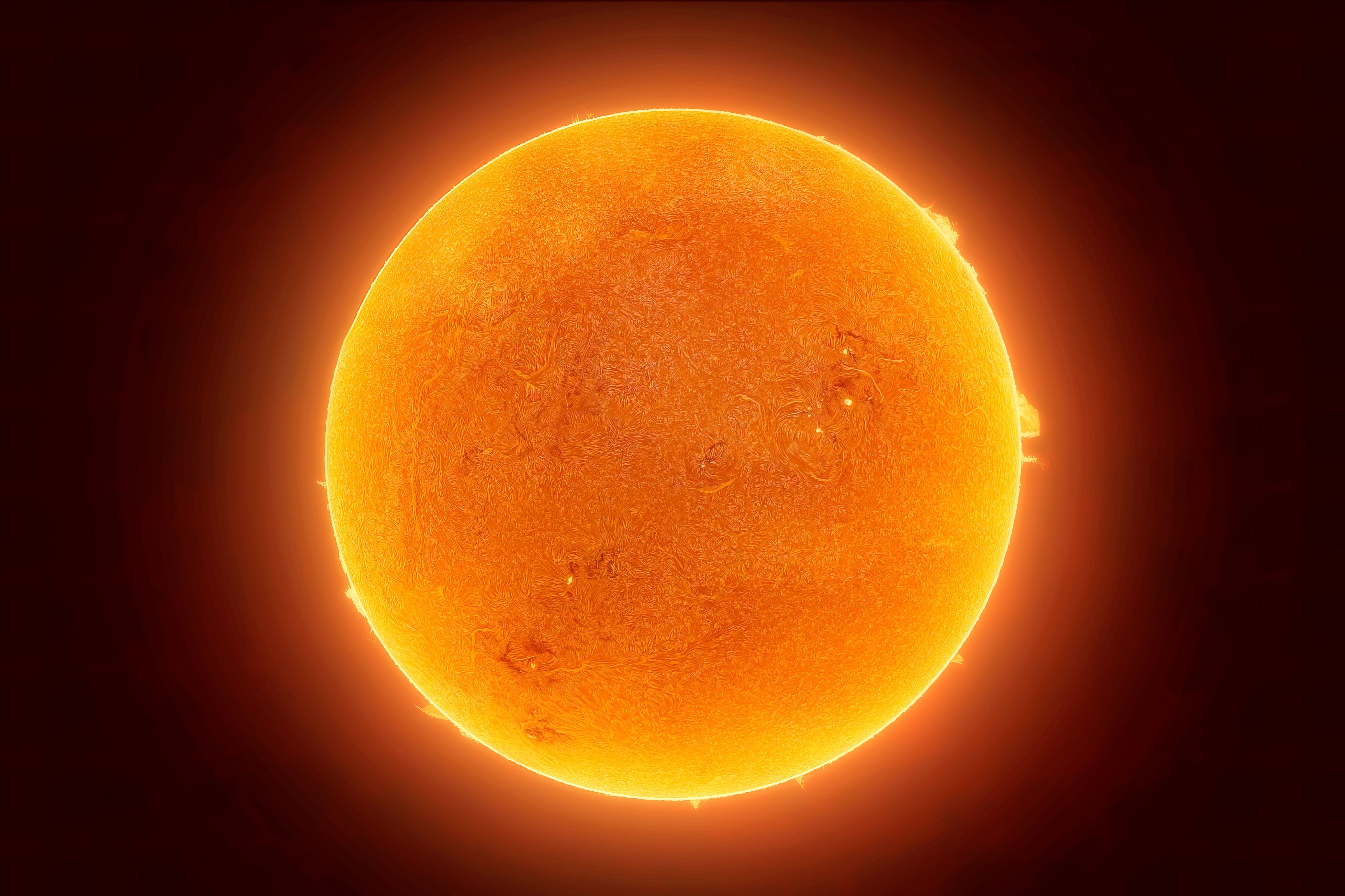 Leuchtende Nahaufnahme der Sonnenoberfläche im H-Alpha-Licht mit sichtbaren Protuberanzen.