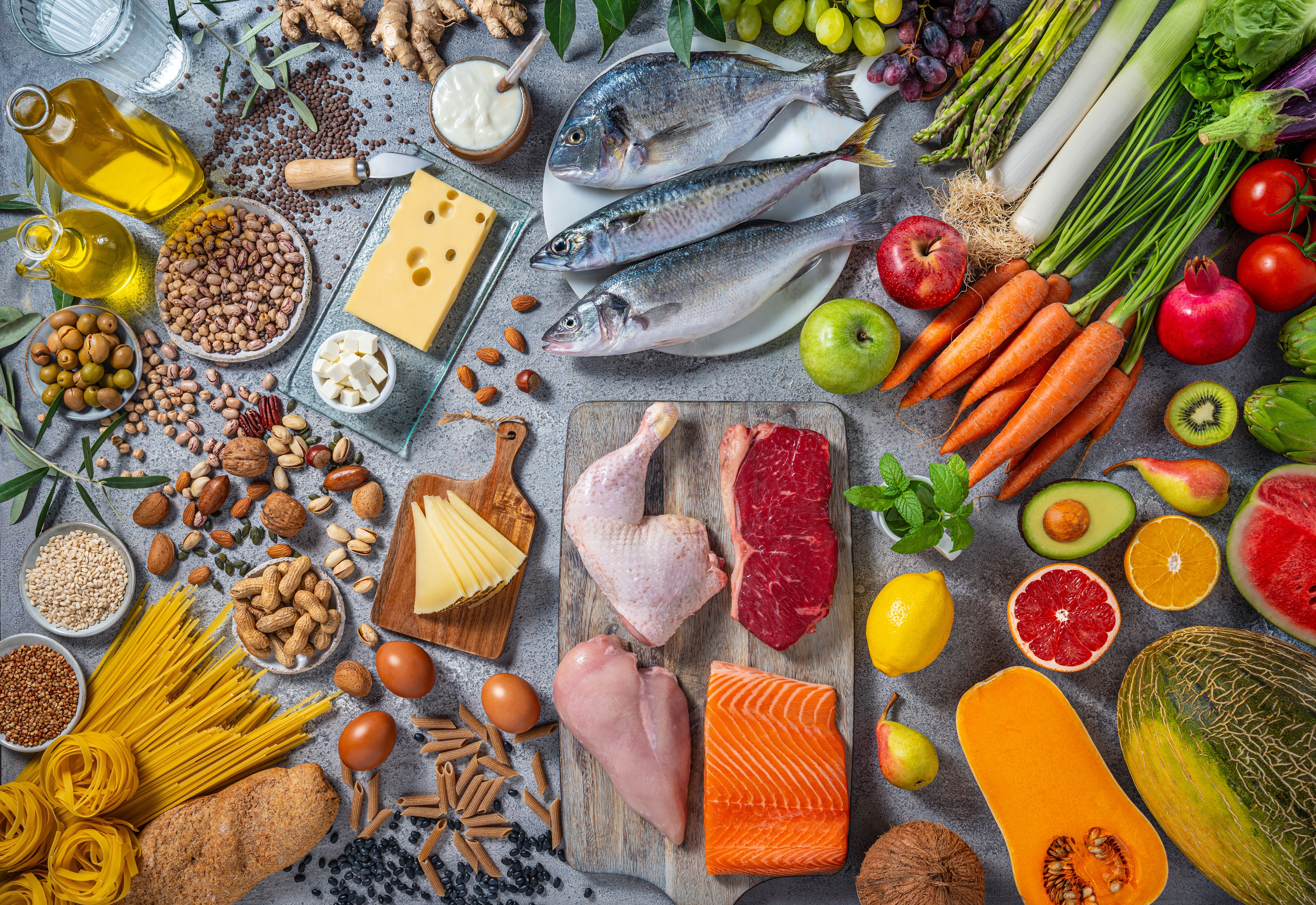 Mediterrane Lebensmittel wie Fisch, Gemüse, Obst, Nüsse, Käse, Getreide und Olivenöl.