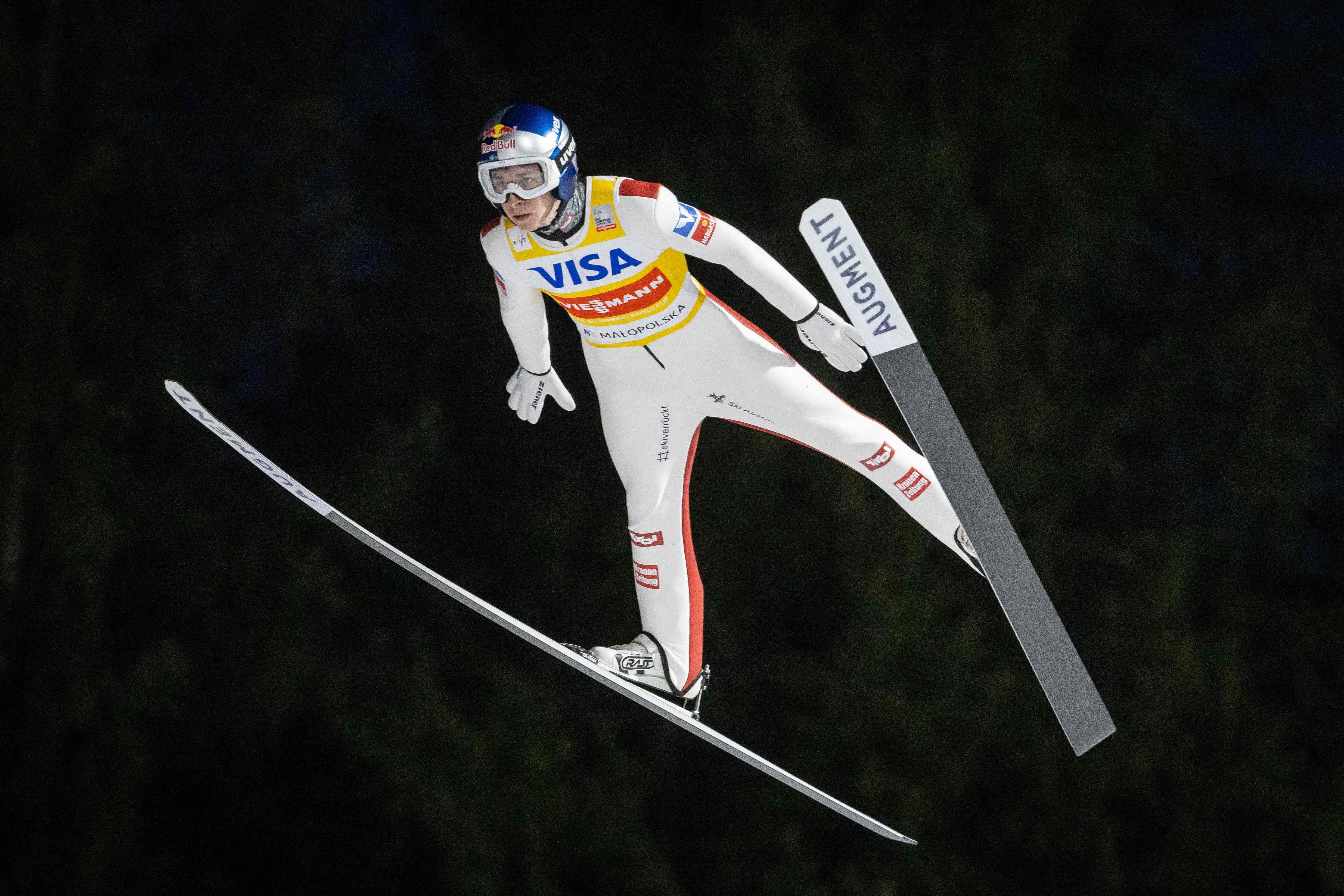 Ein Skispringer fliegt während eines Wettkampfs in kompletter Ausrüstung durch die Luft.