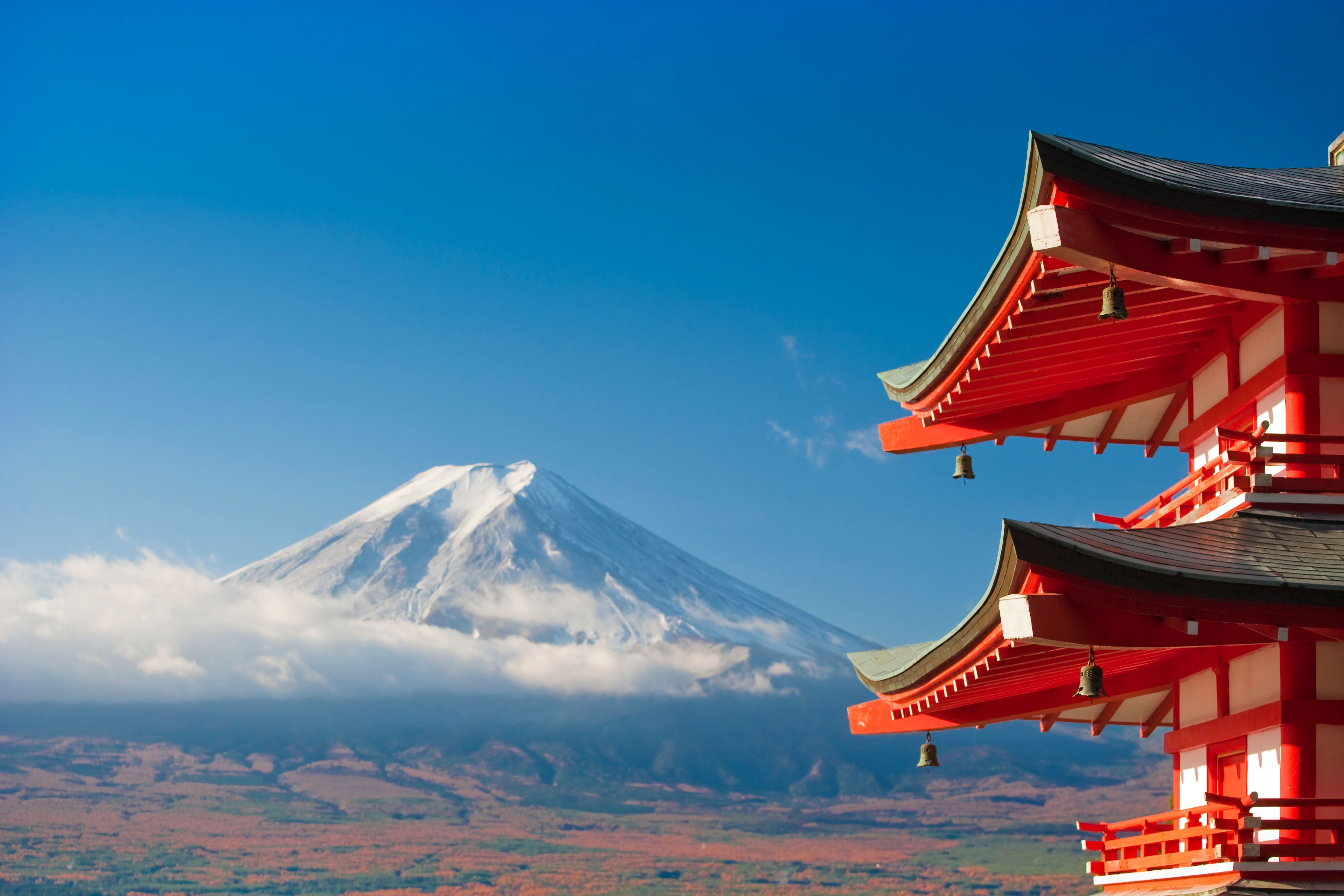 Schneebedeckter Fuji mit traditionellem japanischen Tempel im Vordergrund bei klarem Himmel.