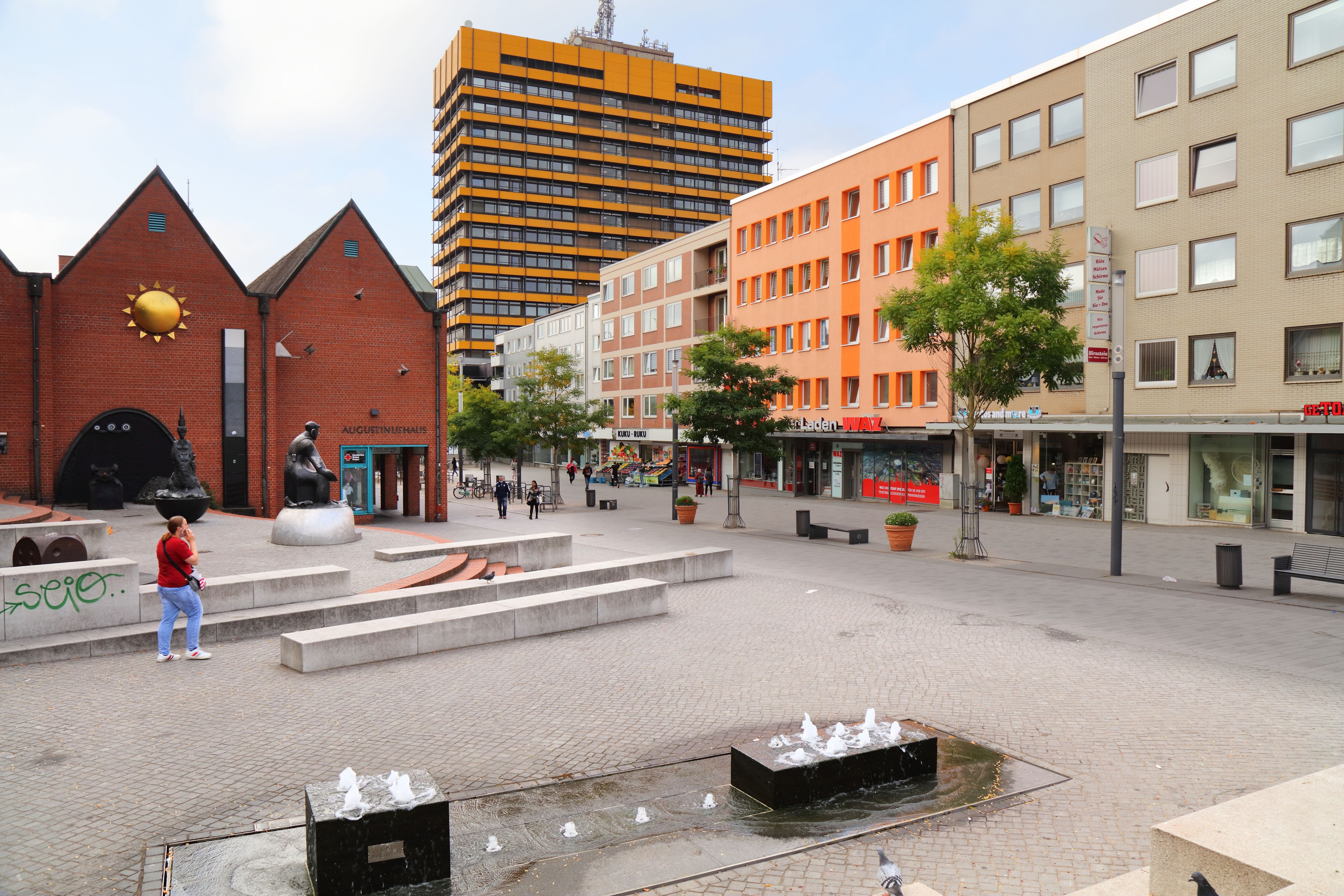 Stadtplatz an der Ahstraße in Gelsenkirchen mit Brunnen, Skulpturen und umliegenden Gebäuden.