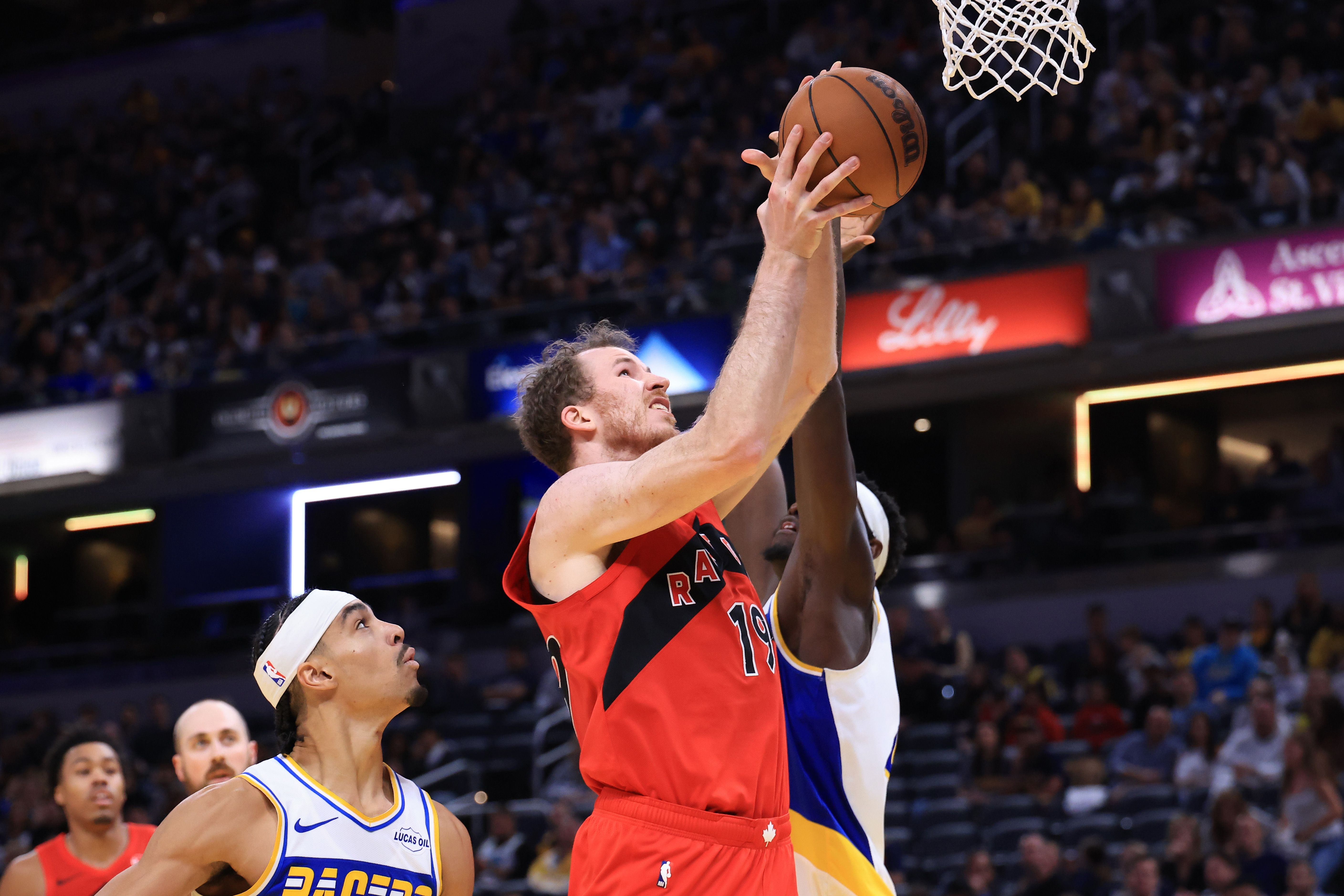 Ein Basketballspieler der Raptors wirft den Ball zum Korb, verteidigt von Spielern der Pacers.