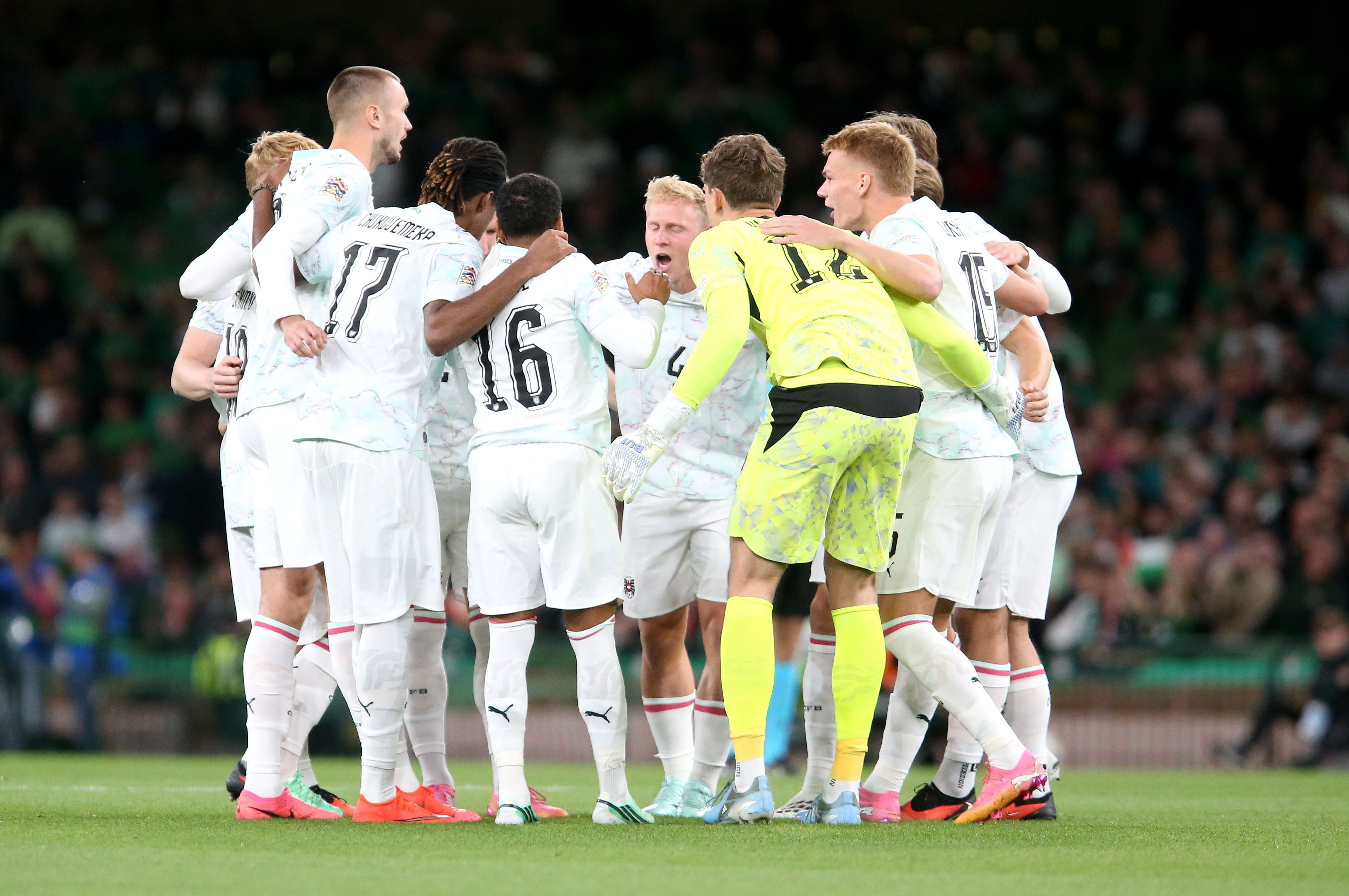 Österreichische Fußballspieler stehen vor einem Spiel auf dem Rasen im Kreis und motivieren sich.