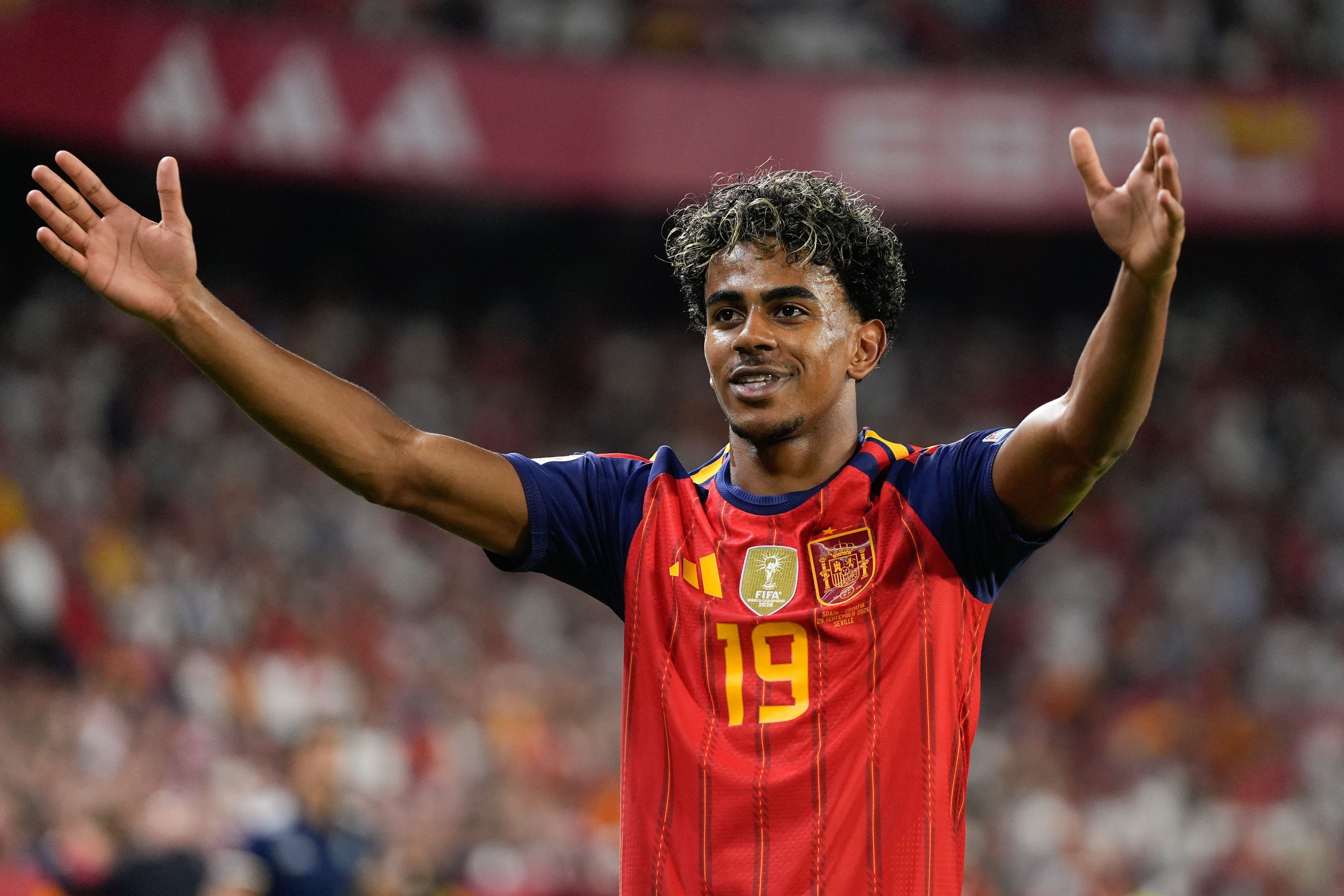 Lamine Yamal jubelt im roten Trikot der spanischen Nationalmannschaft mit ausgebreiteten Armen.