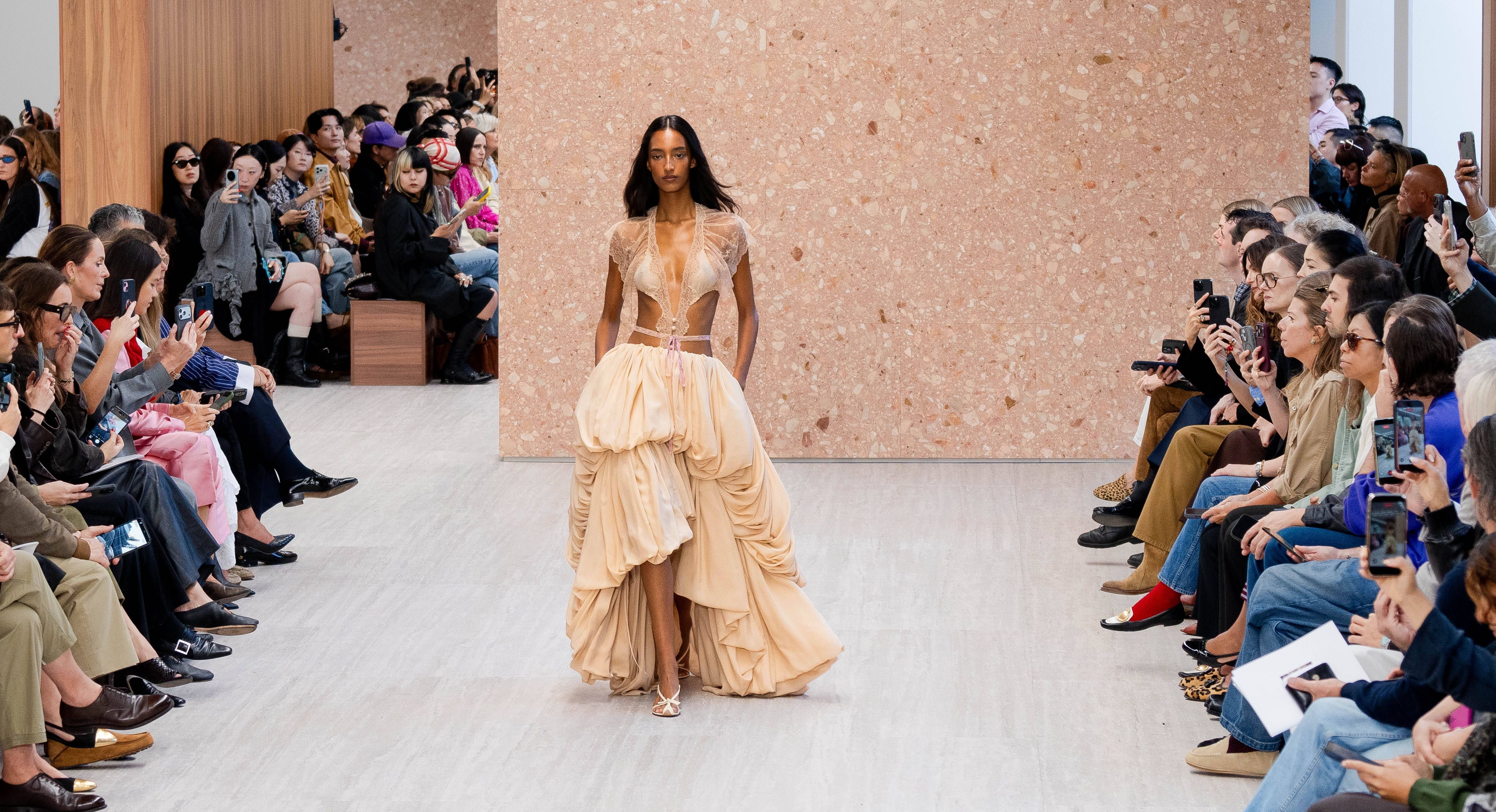 Model läuft in cremefarbenem, voluminösem Kleid über den Laufsteg der Pariser Fashion Week.