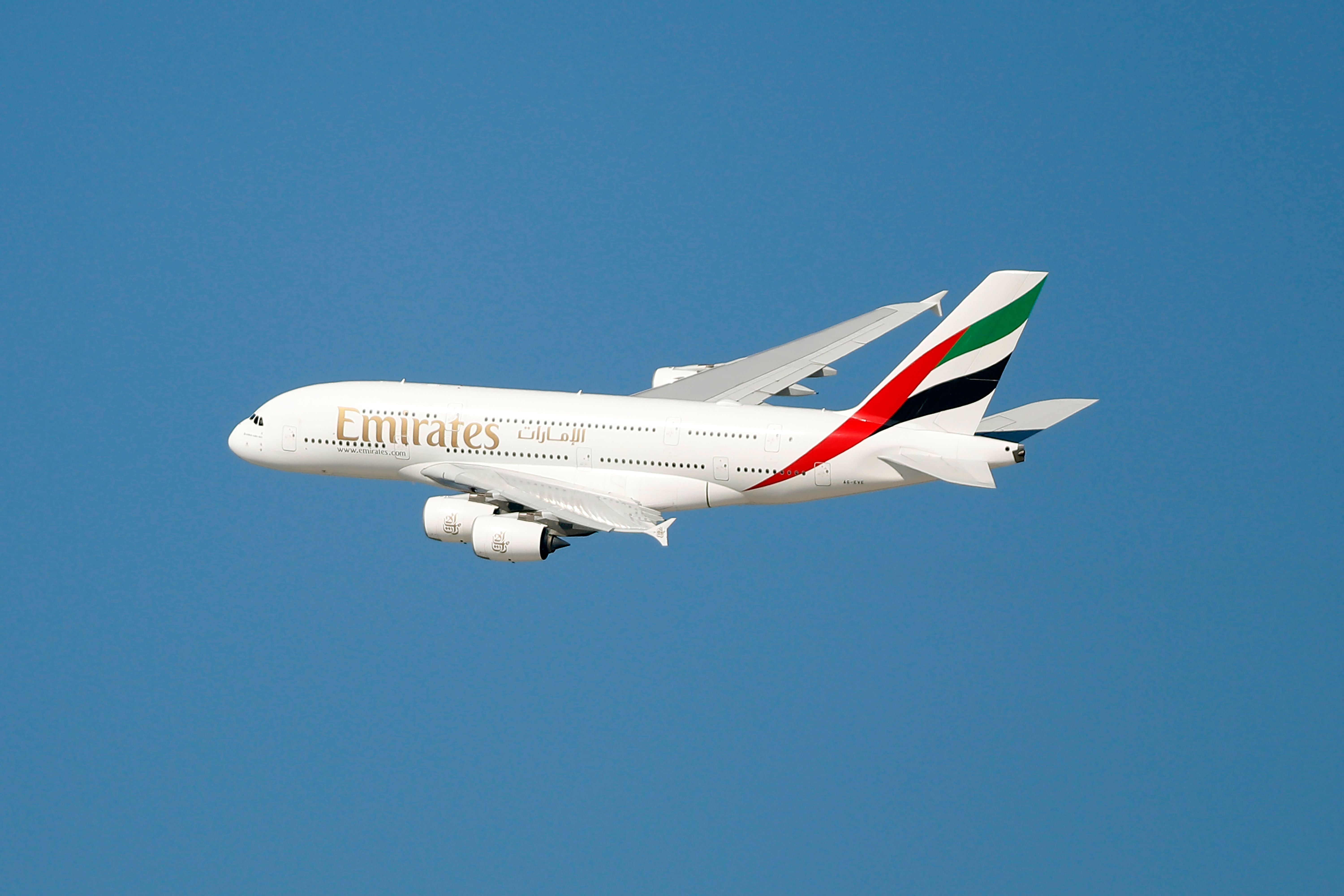 Ein Emirates Airbus A380 fliegt vor klarem, blauem Himmel.
