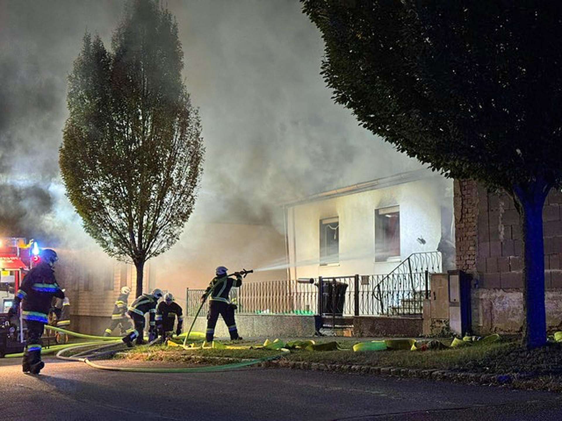 Feuerwehr löscht Brand in einem Einfamilienhaus in Klingenbach, dichter Rauch steigt auf.