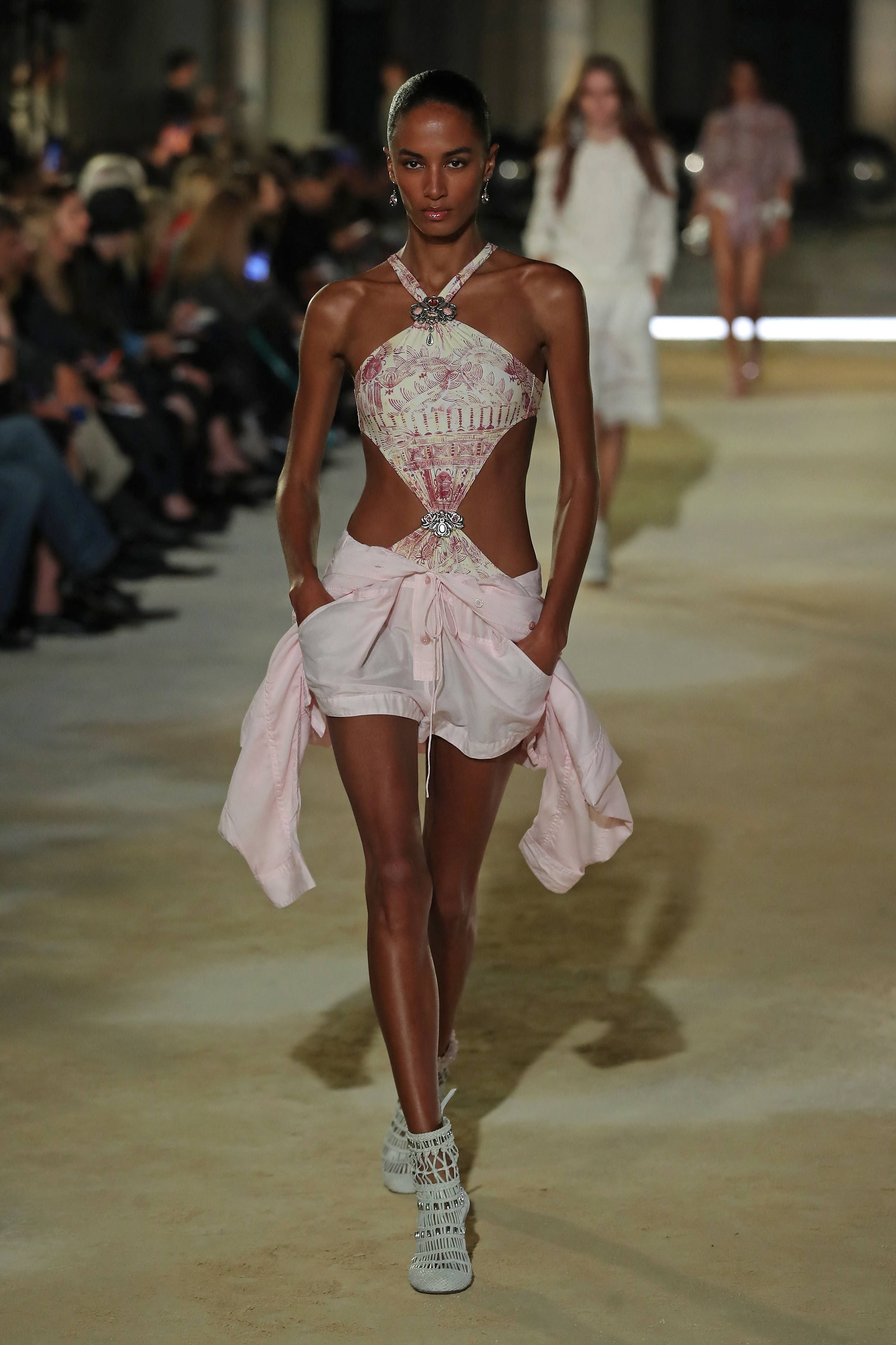 Model in pink gemverziertem Cut-Out-Oberteil und Shorts auf dem Laufsteg der Paris Fashion Week.