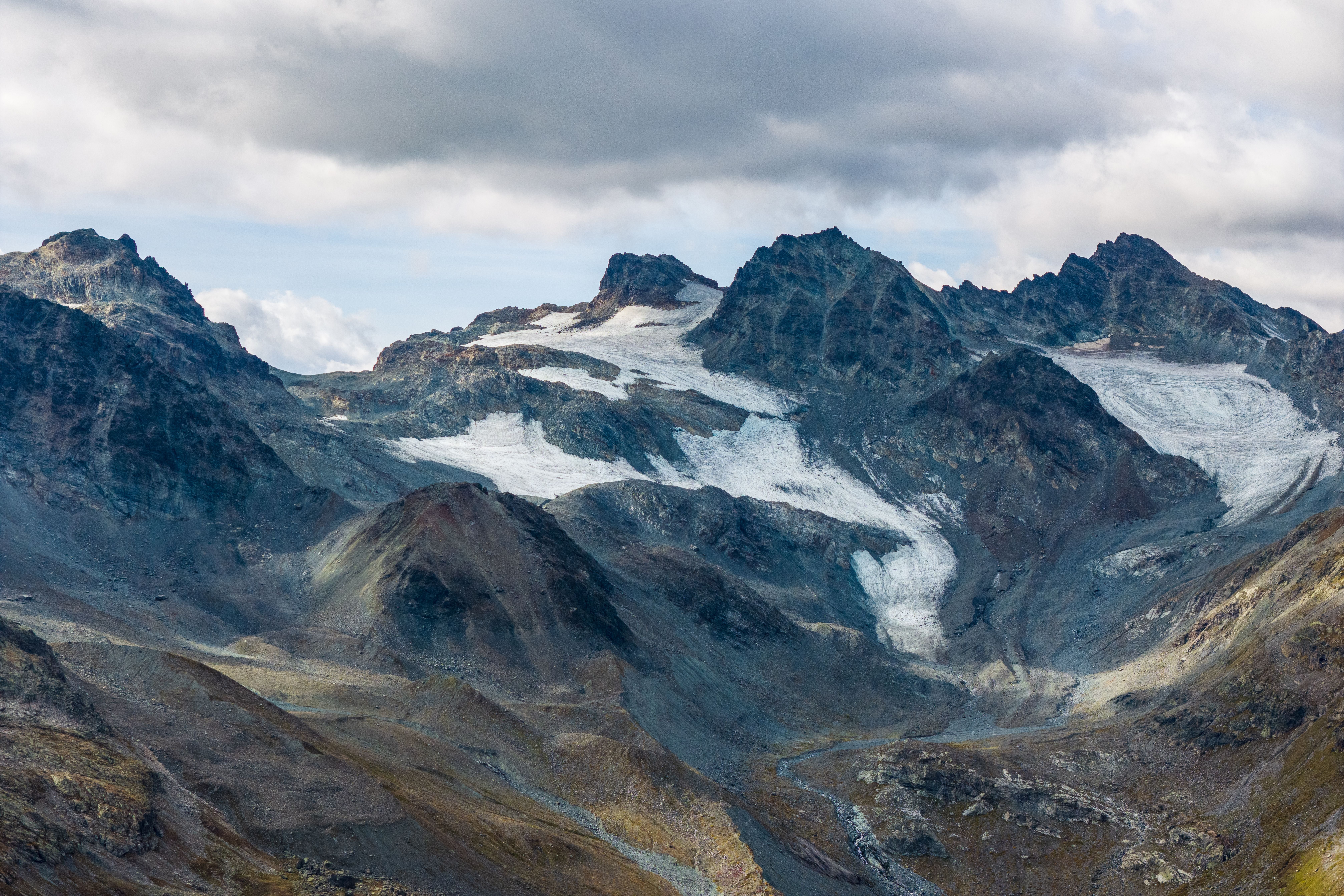 Gletscher und Berggipfel in den Alpen bei Galtür unter bewölktem Himmel.