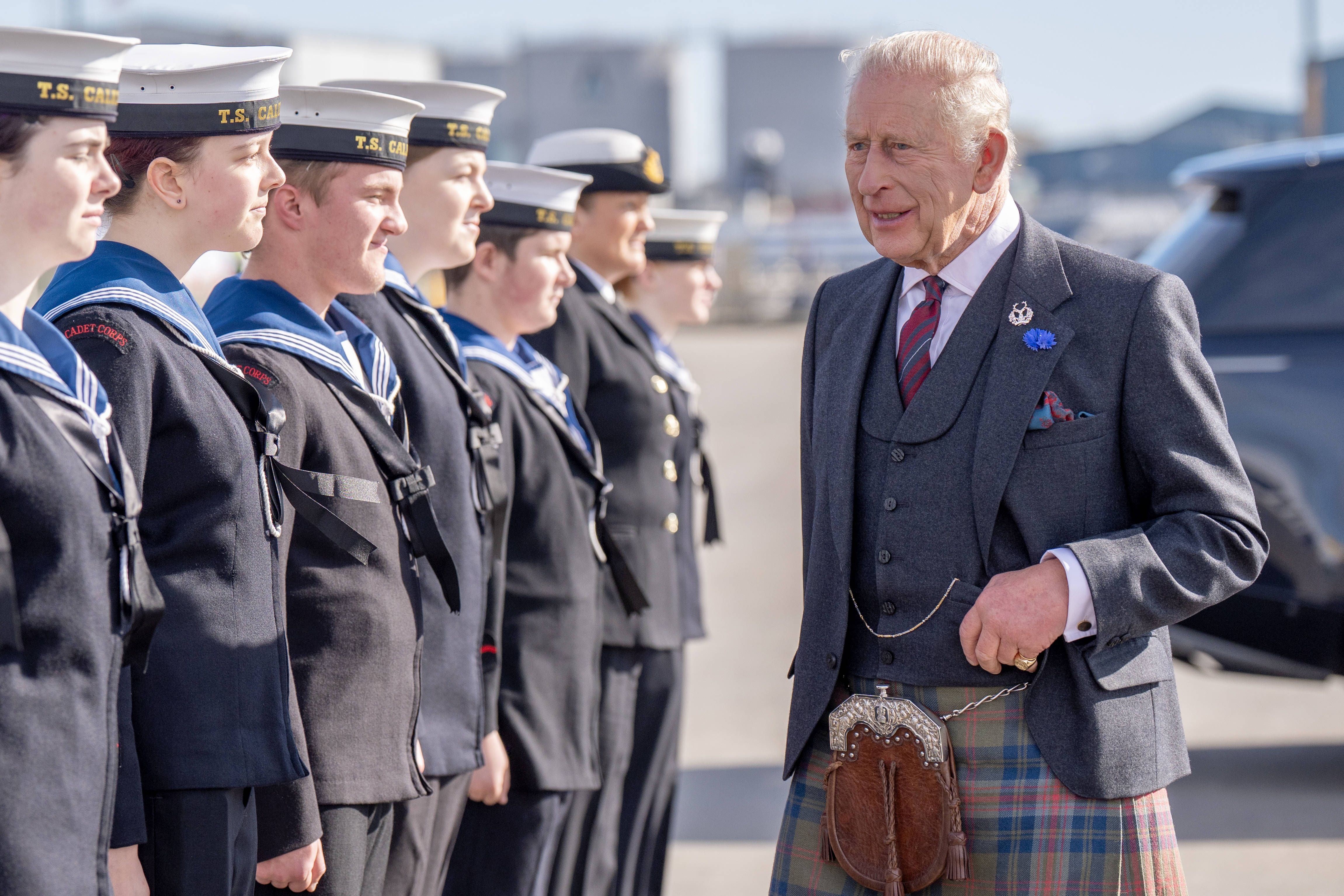 König Charles III spricht mit einer Reihe junger Sea Cadets am Hafen bei sonnigem Wetter.